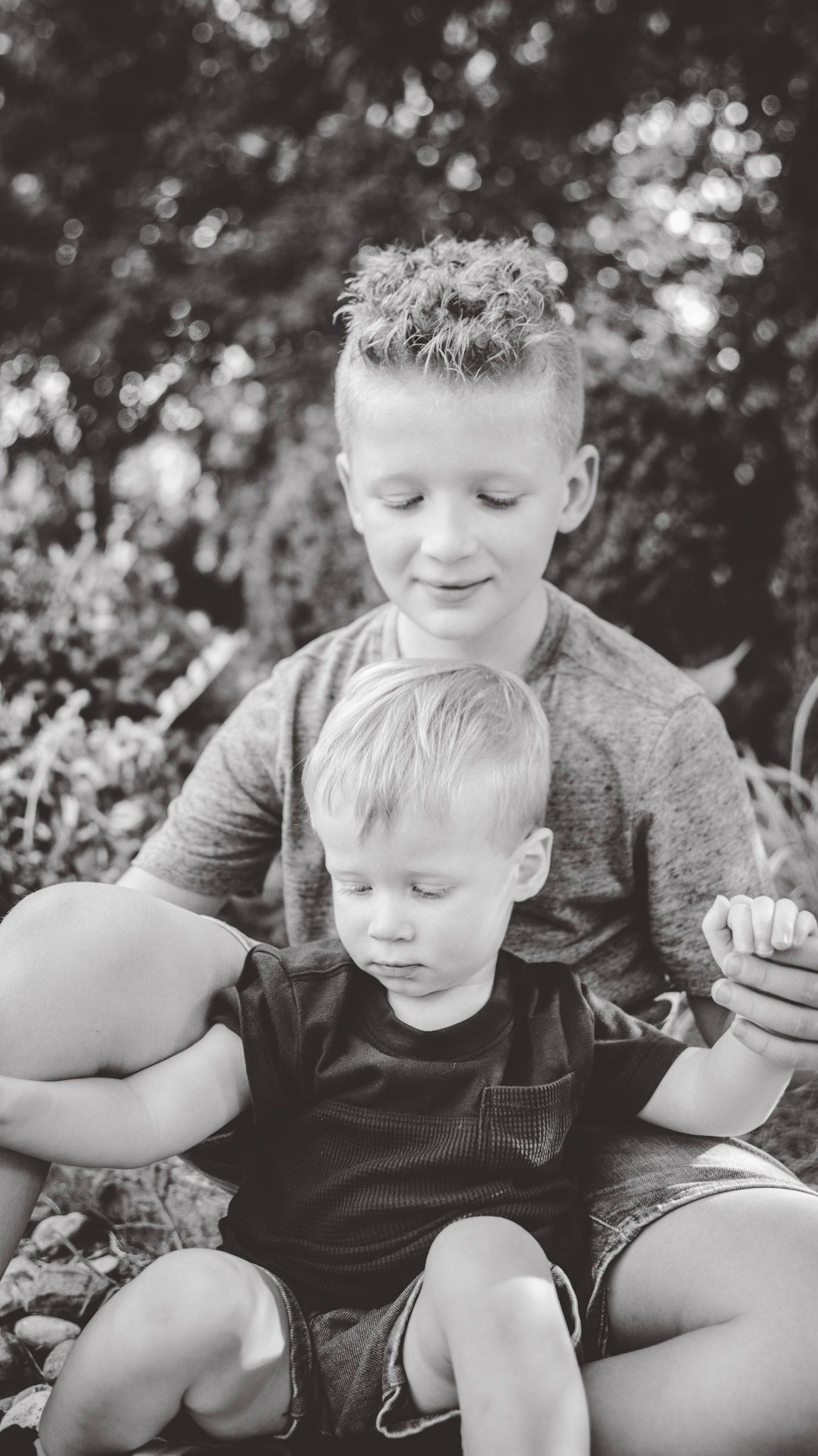 Black and white series of two people sharing a tender moment outdoors.