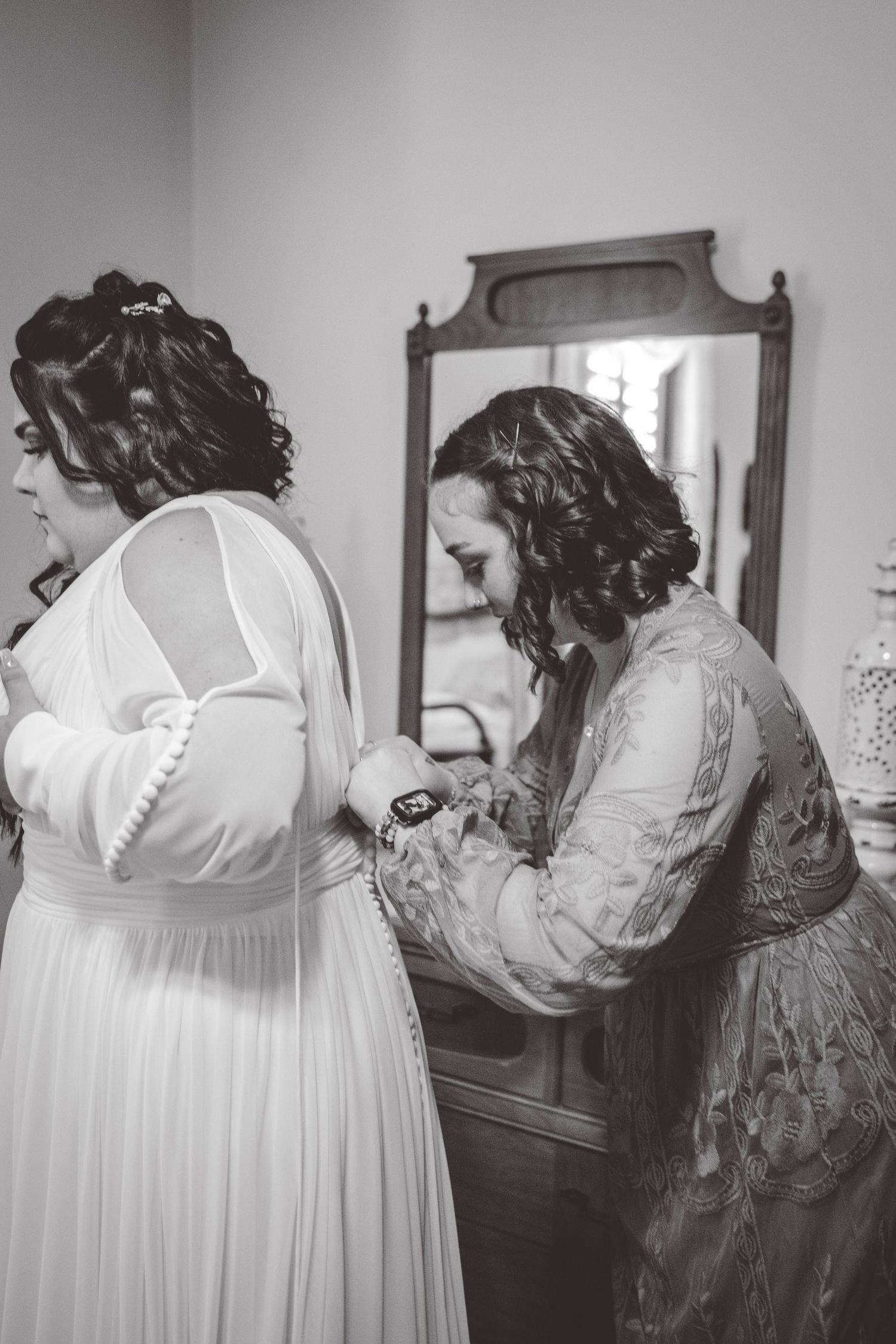 Wedding dress preparation scene with vintage furniture and mirrors.