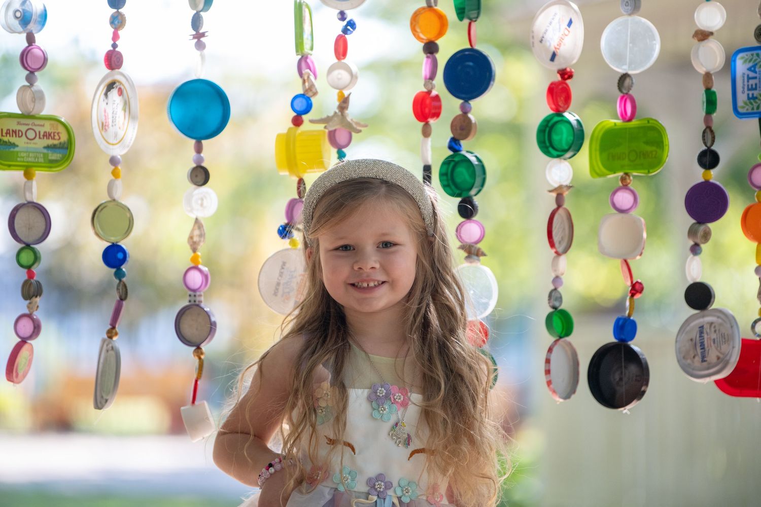 Magical outdoor photoshoot featuring hanging rainbow decorations and whimsical lighting.
