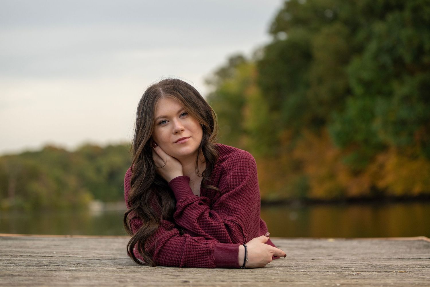 Outdoor photo shoot featuring relaxed poses against an autumn landscape.