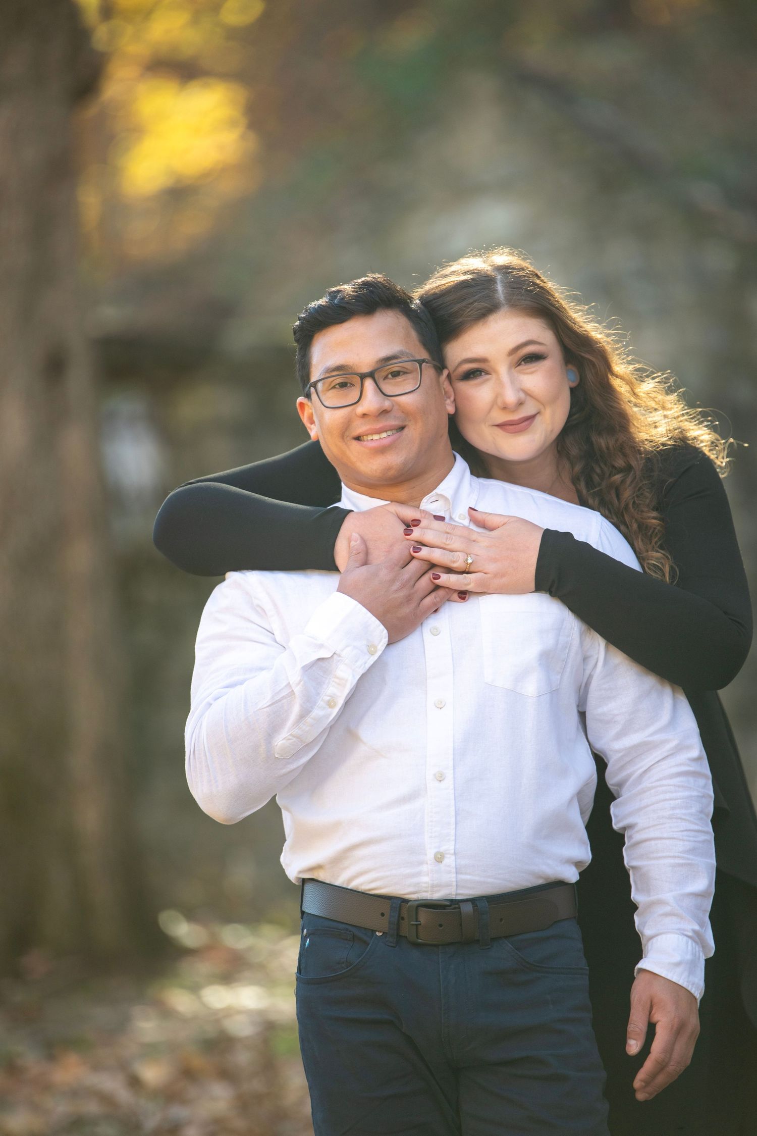 Playful engagement photo with couple in black and white outfits.