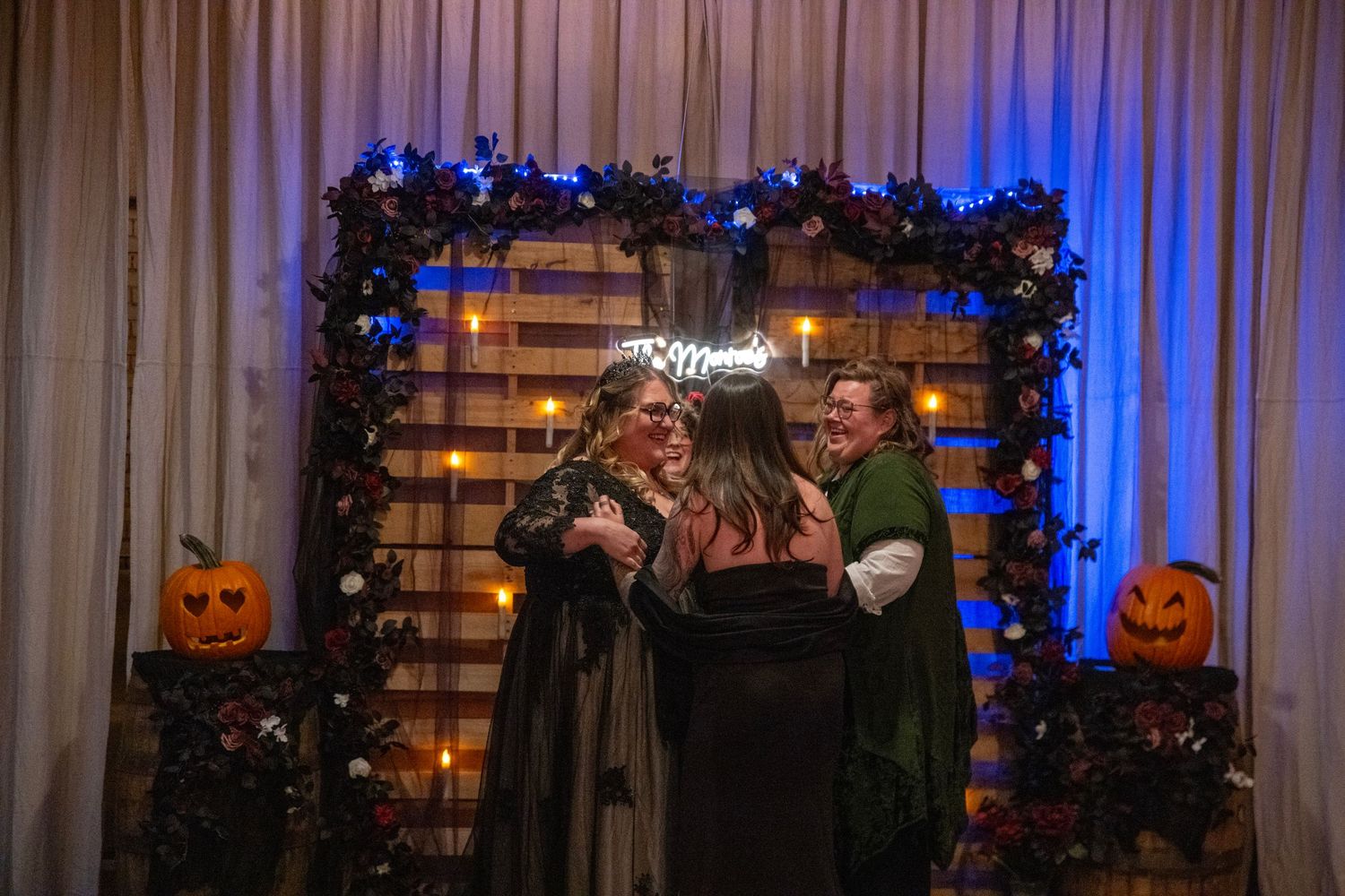 Wedding ceremony space with string lights, floral arrangements and Halloween-themed decorations.
