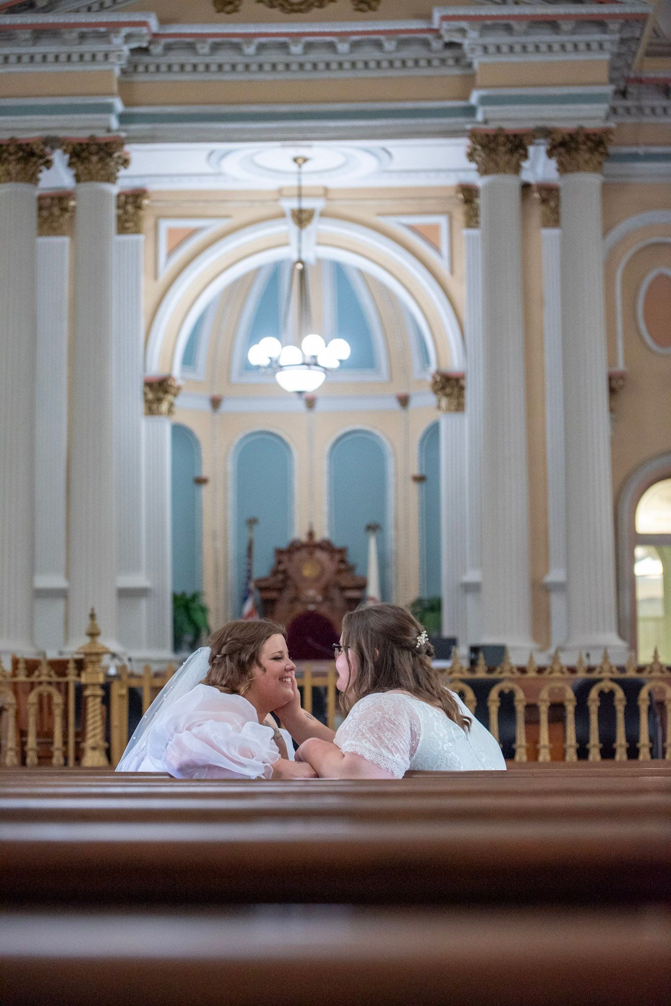 Wide view of courthouse wedding through decorative railing with classical architecture.