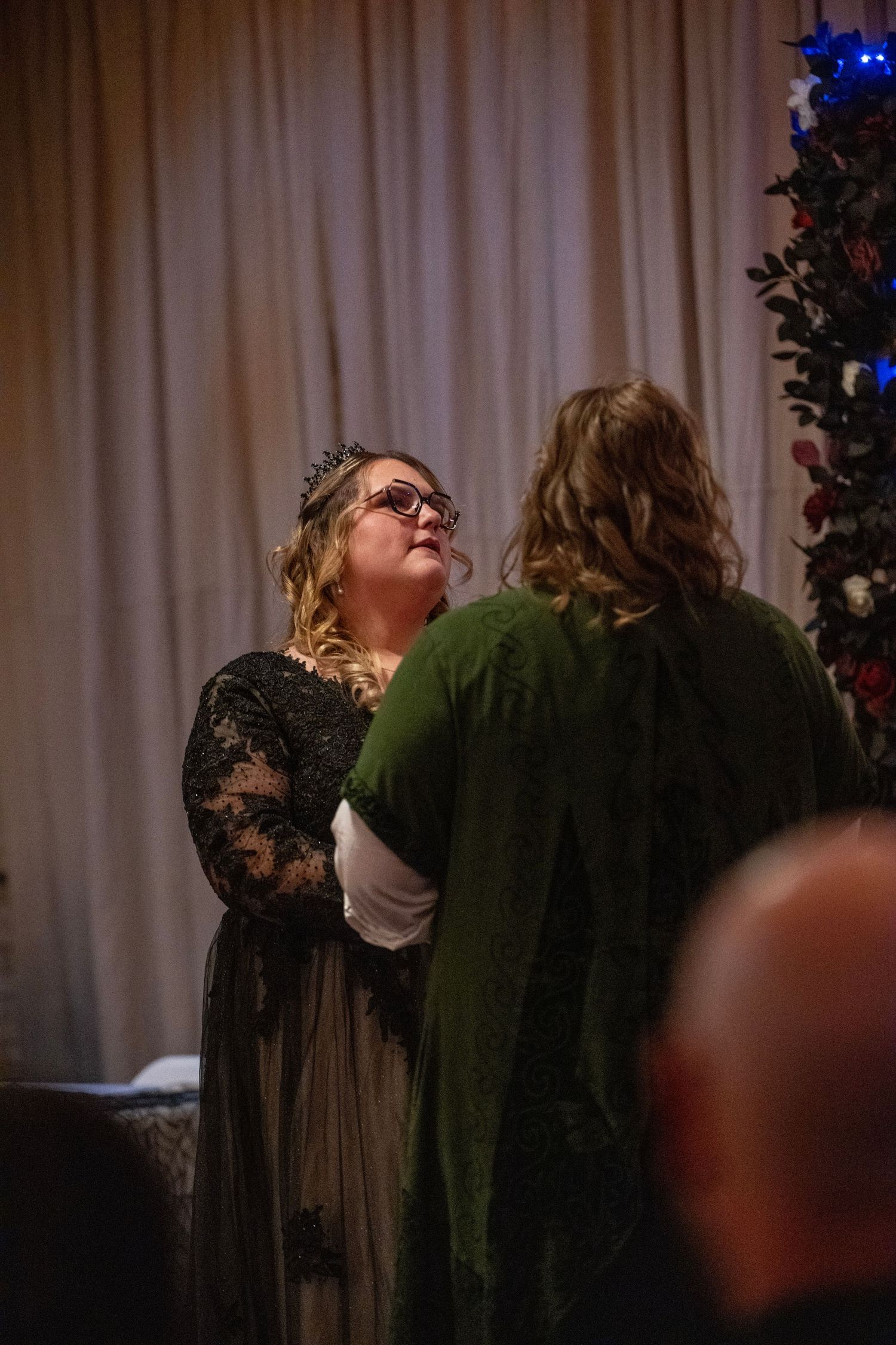Couple embracing during emotional wedding ceremony moment with decorative lighting and autumn decor.