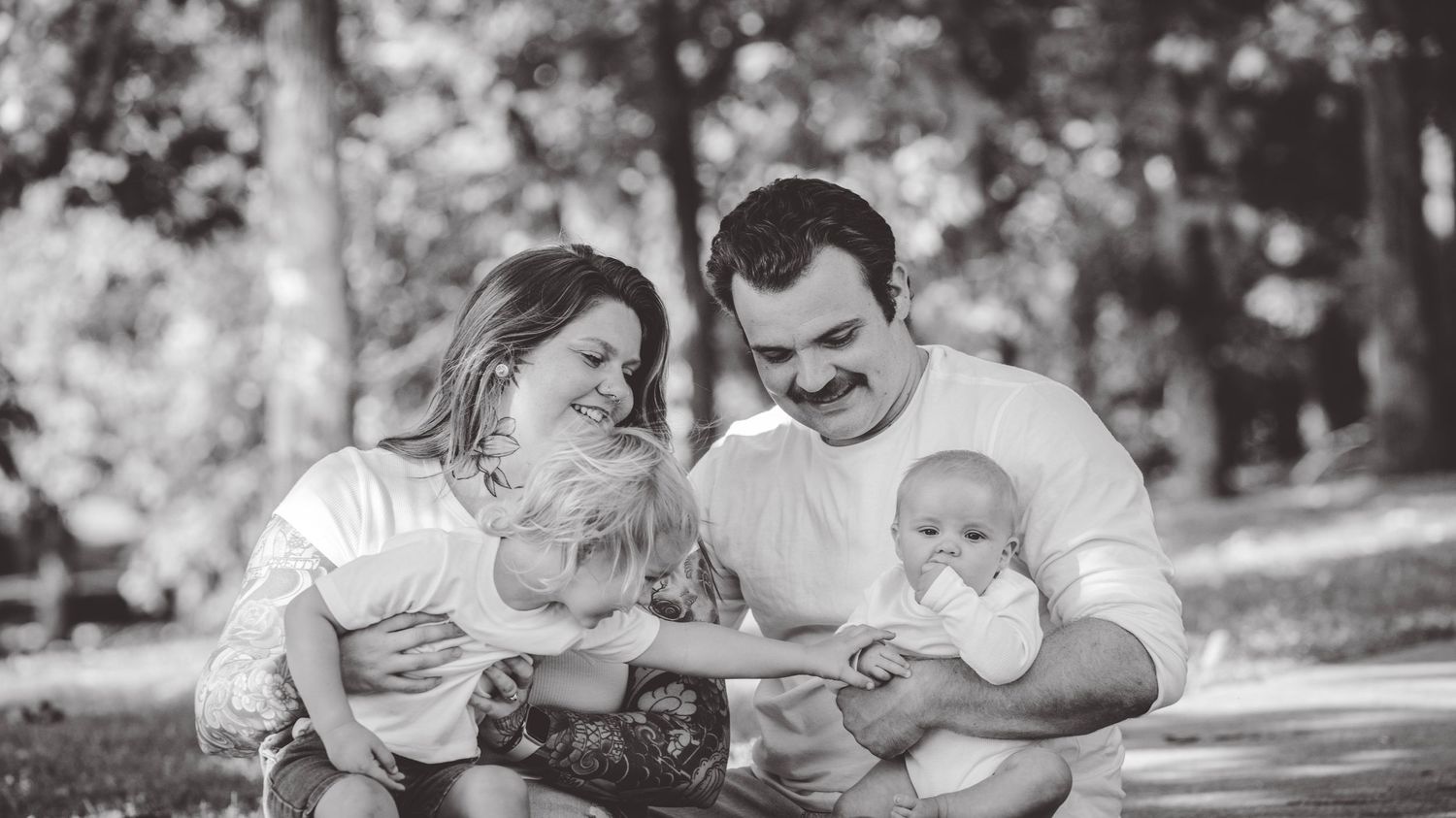 Black and white panoramic series of family moments outdoors.