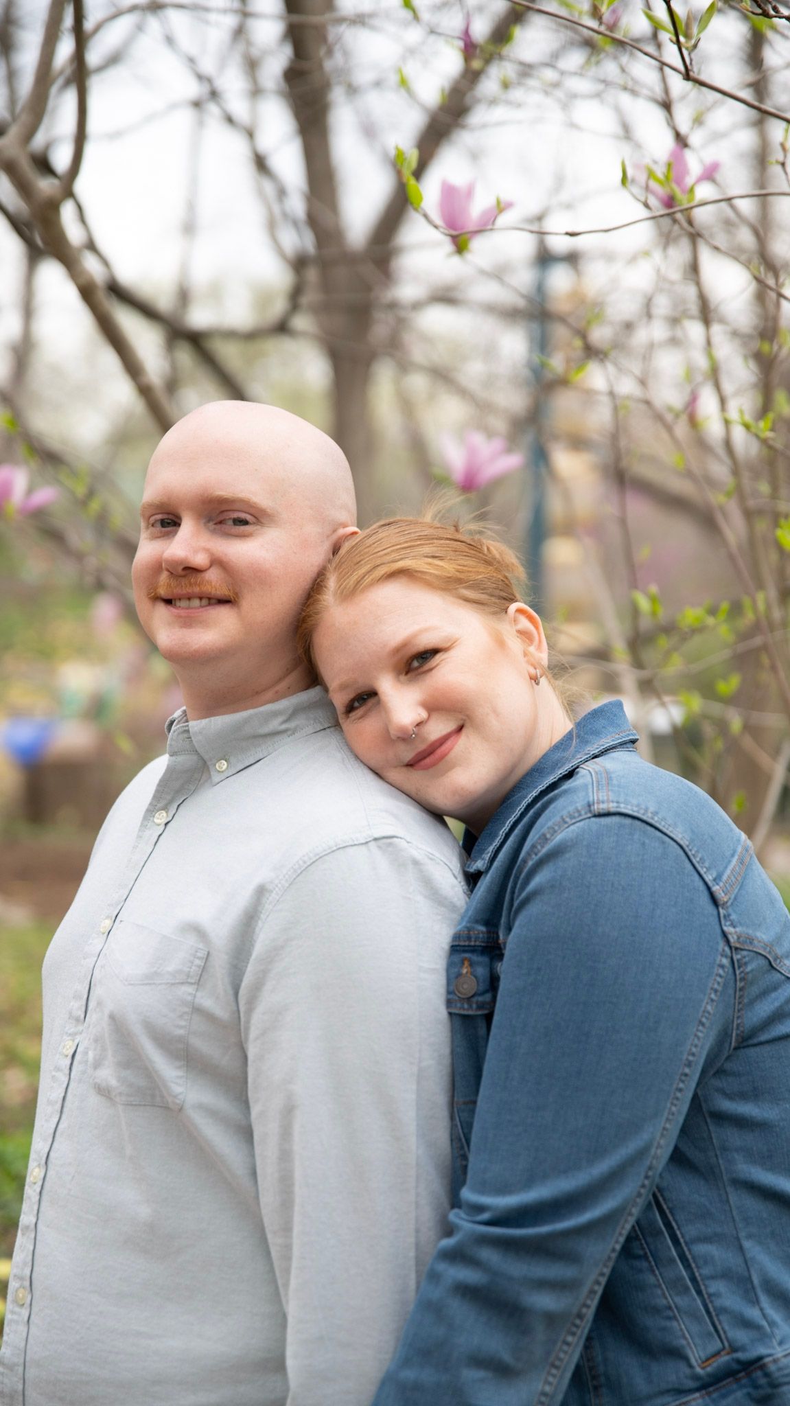 A springtime portrait with blooming magnolia trees in the background.