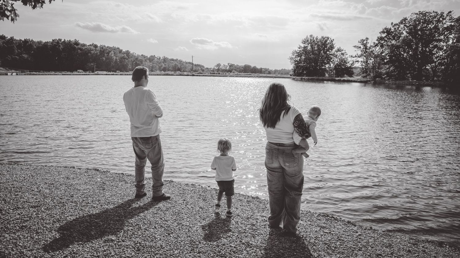 Black and white panoramic view of people enjoying a peaceful day by the lake.