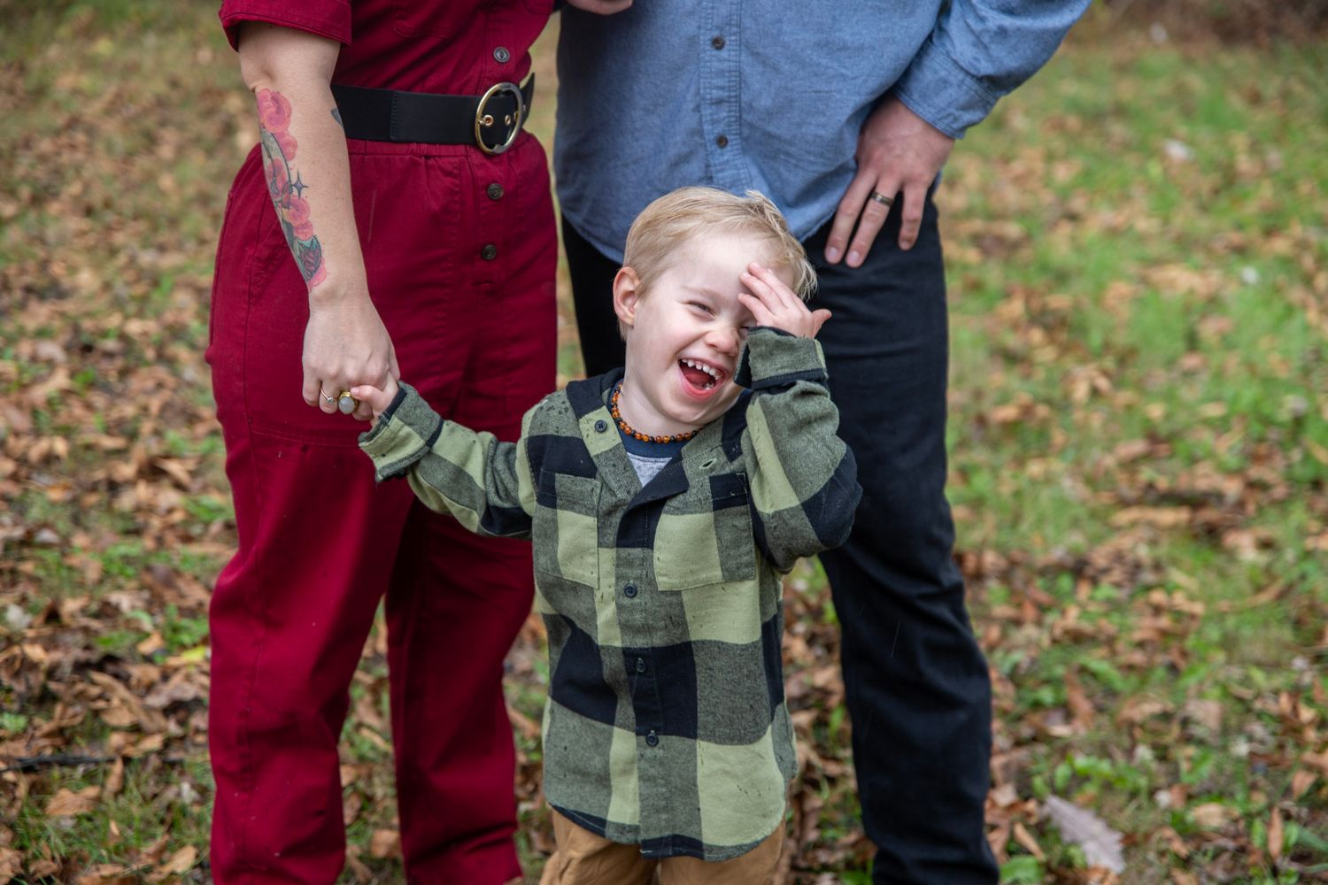 Candid outdoor family moment captured in autumn with plaid and burgundy clothing.