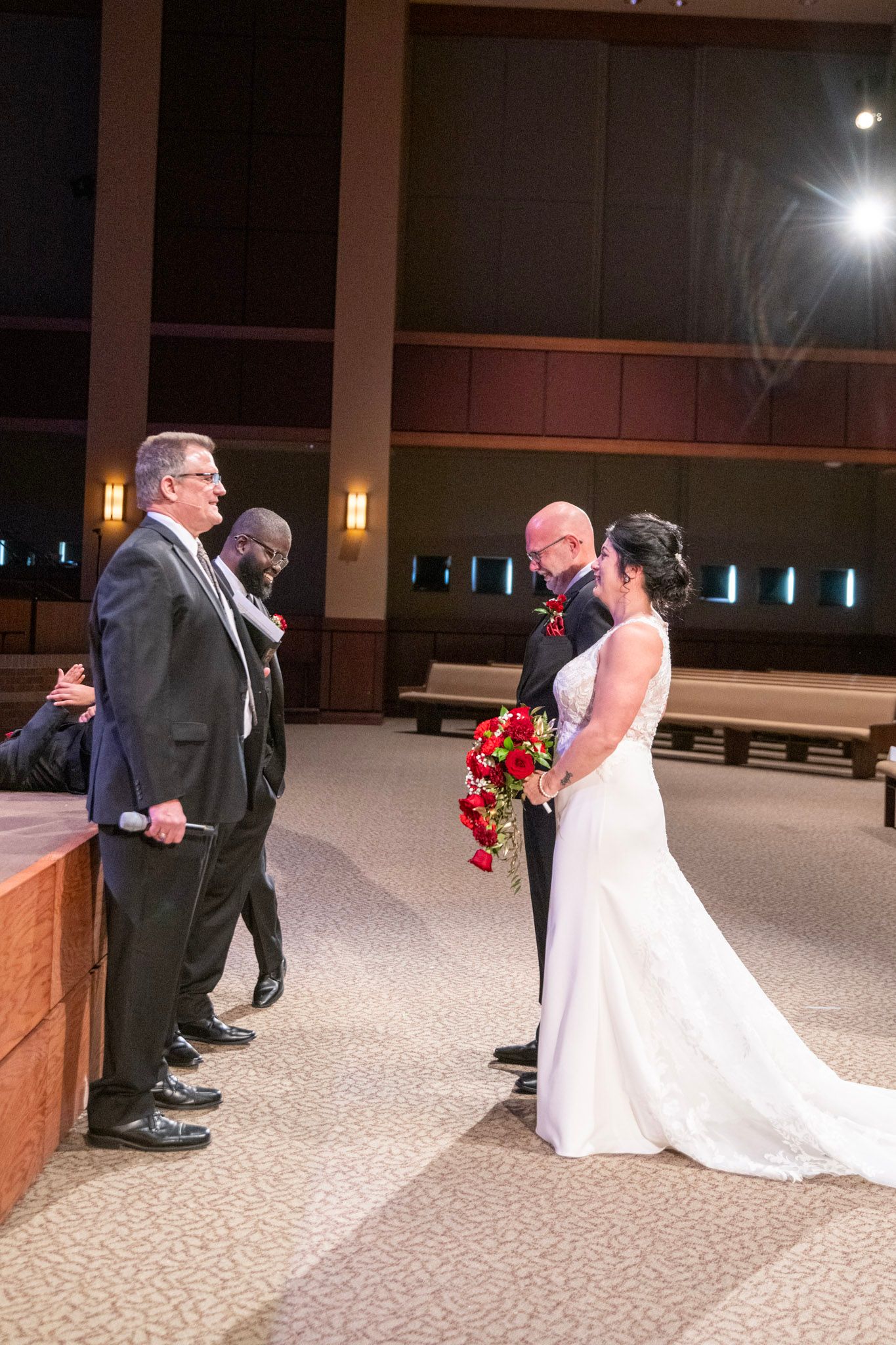 Wedding ceremony sequence in modern church with red floral decorations.
