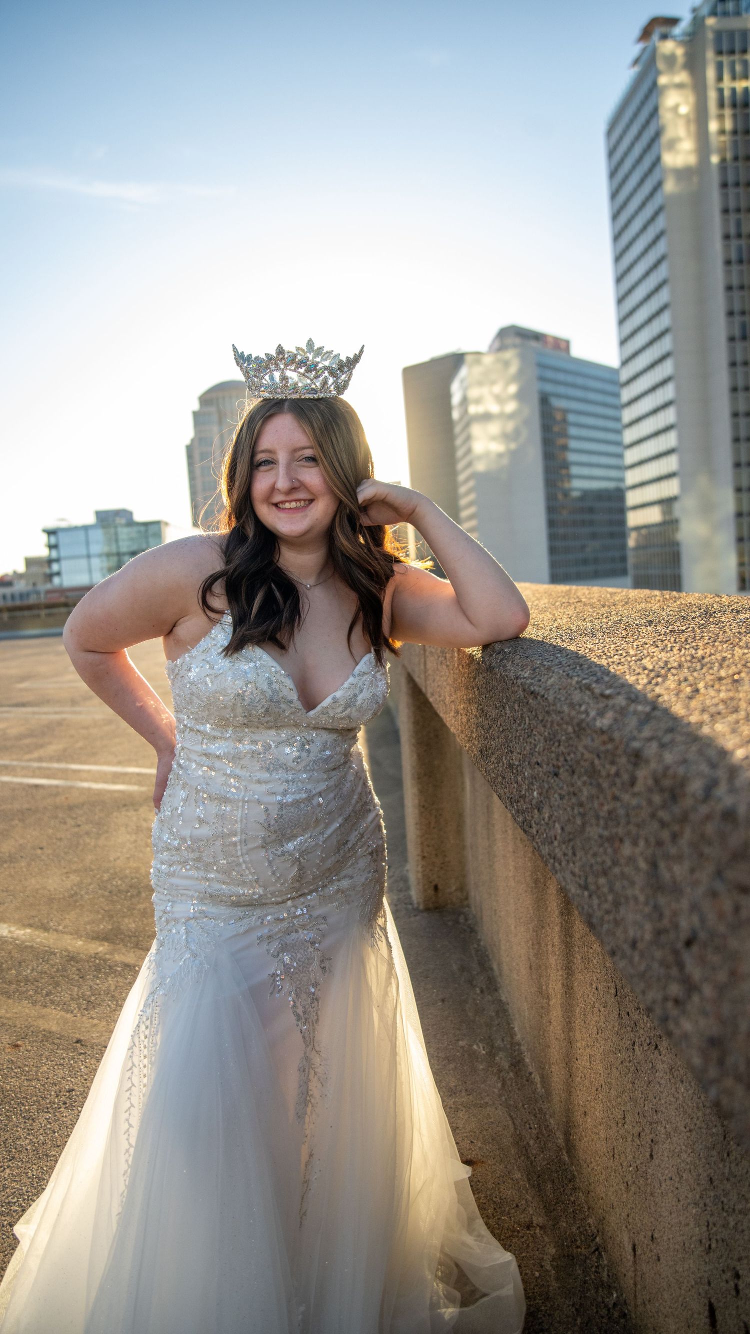 A sparkly white formal dress photoshoot against an urban cityscape backdrop.