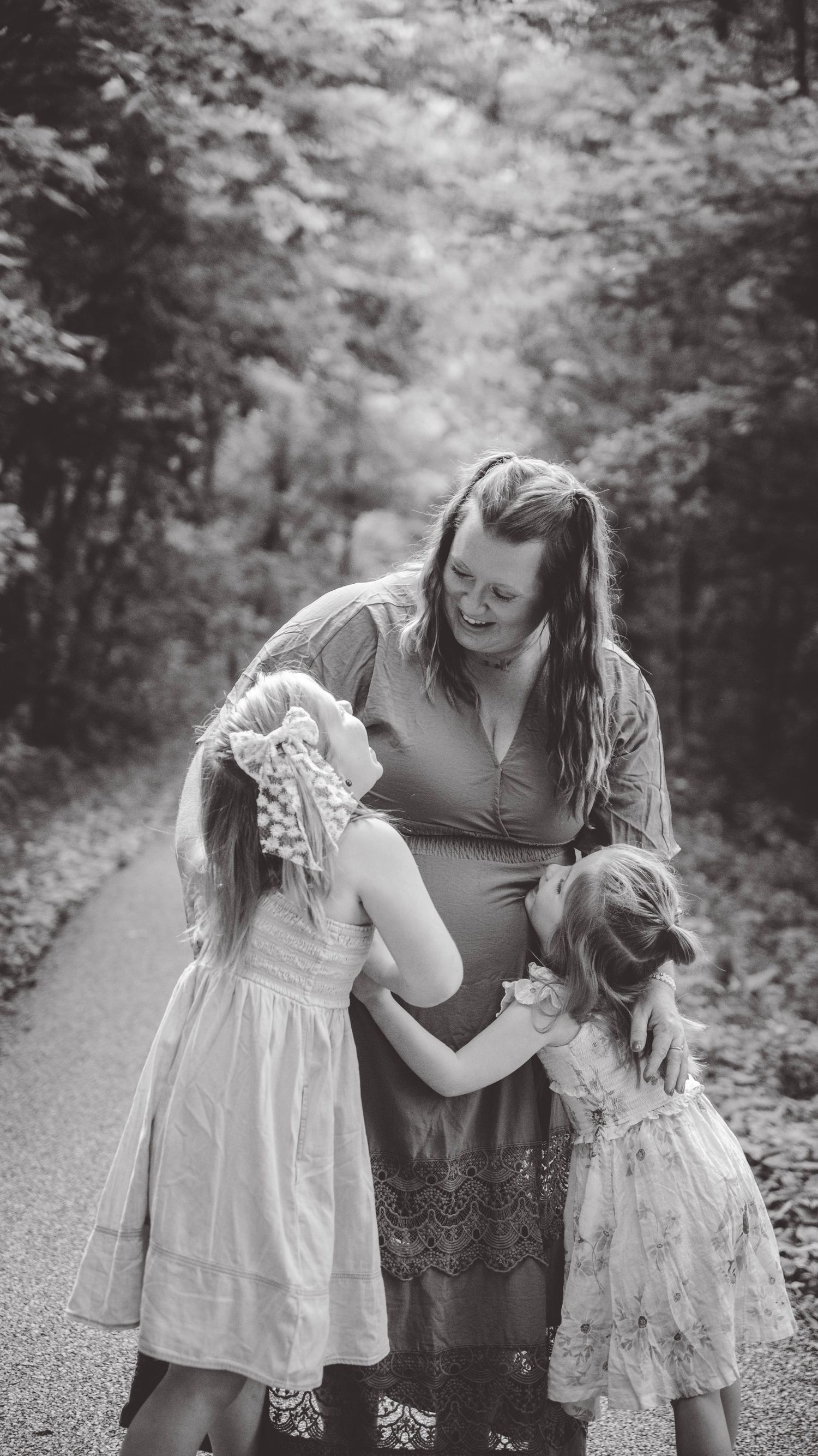 Black and white candid moments captured on a sunlit forest path.