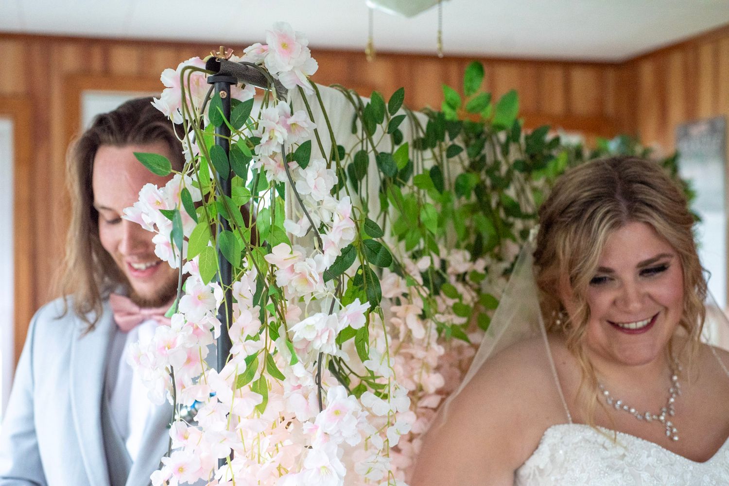 Wedding scene with floral decorations and hanging wisteria.