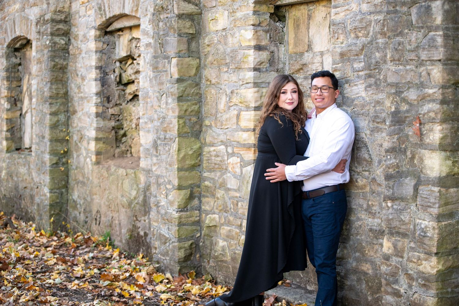 Historic stone colonnade provides architectural backdrop for romantic autumn photoshoot.