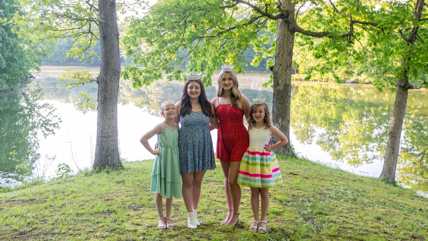 Group photo session taking place near a lake with trees in background.