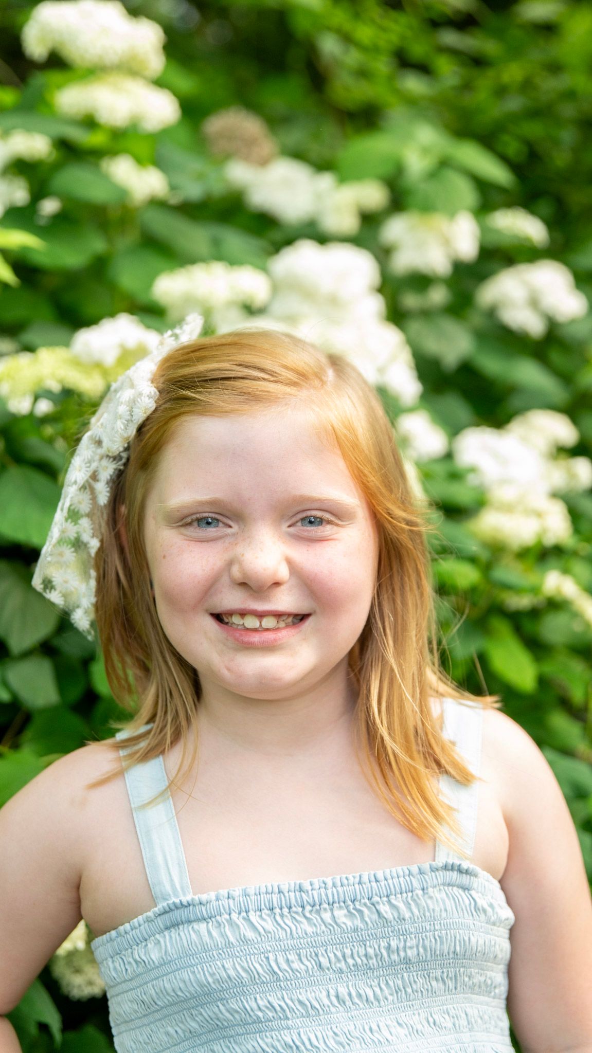 Portrait series with white hydrangea flowers creating a natural summer backdrop.