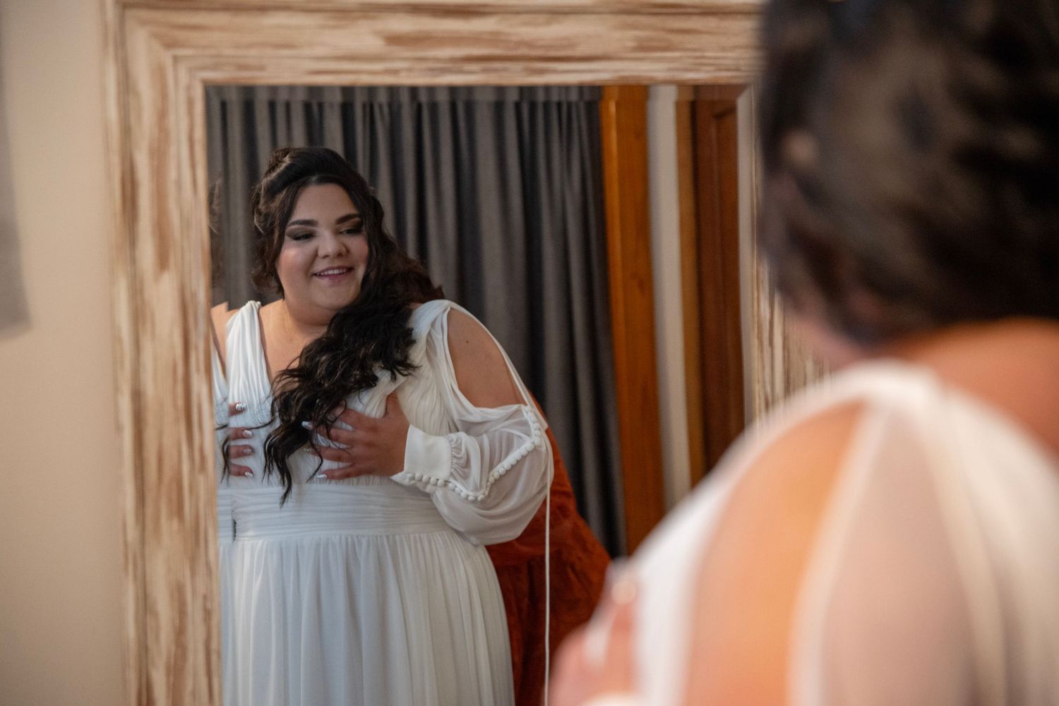 Getting ready scene in indoor setting with white dress visible.