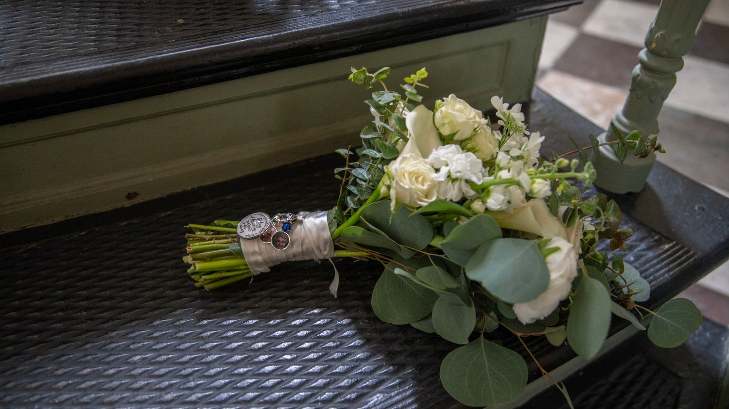 White and green wedding bouquet details against dark textured surface.