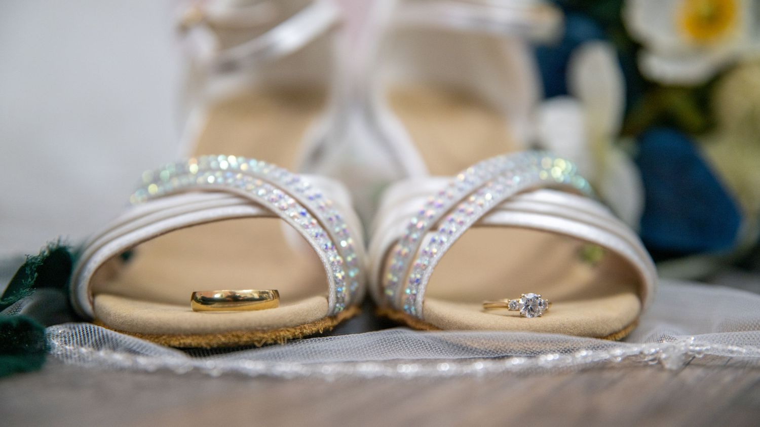 Close-up detail shot of bridal sandals with rhinestone embellishments.