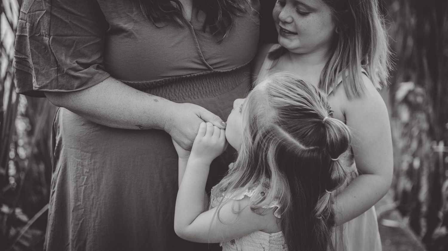 Black and white portrait series showing tender family moments.