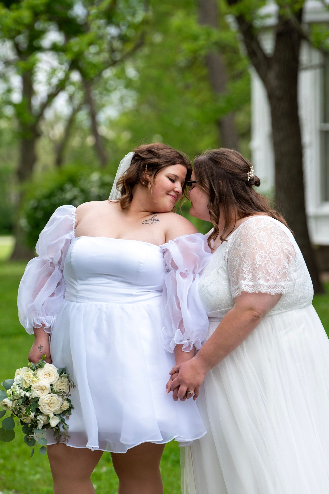 Wedding couple sharing intimate moment among trees and greenery.