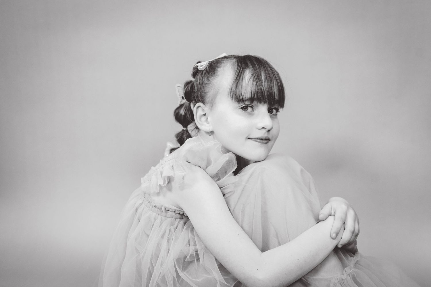 Artistic black and white portrait with flowing tulle fabric.