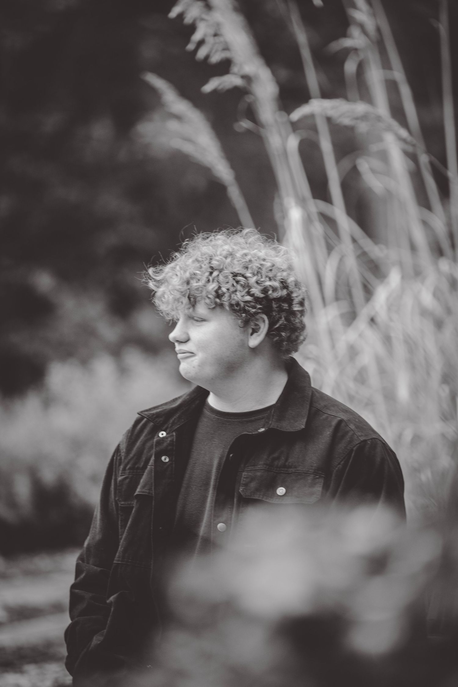 Black and white portraits with tall grass creating a dreamy, artistic effect.