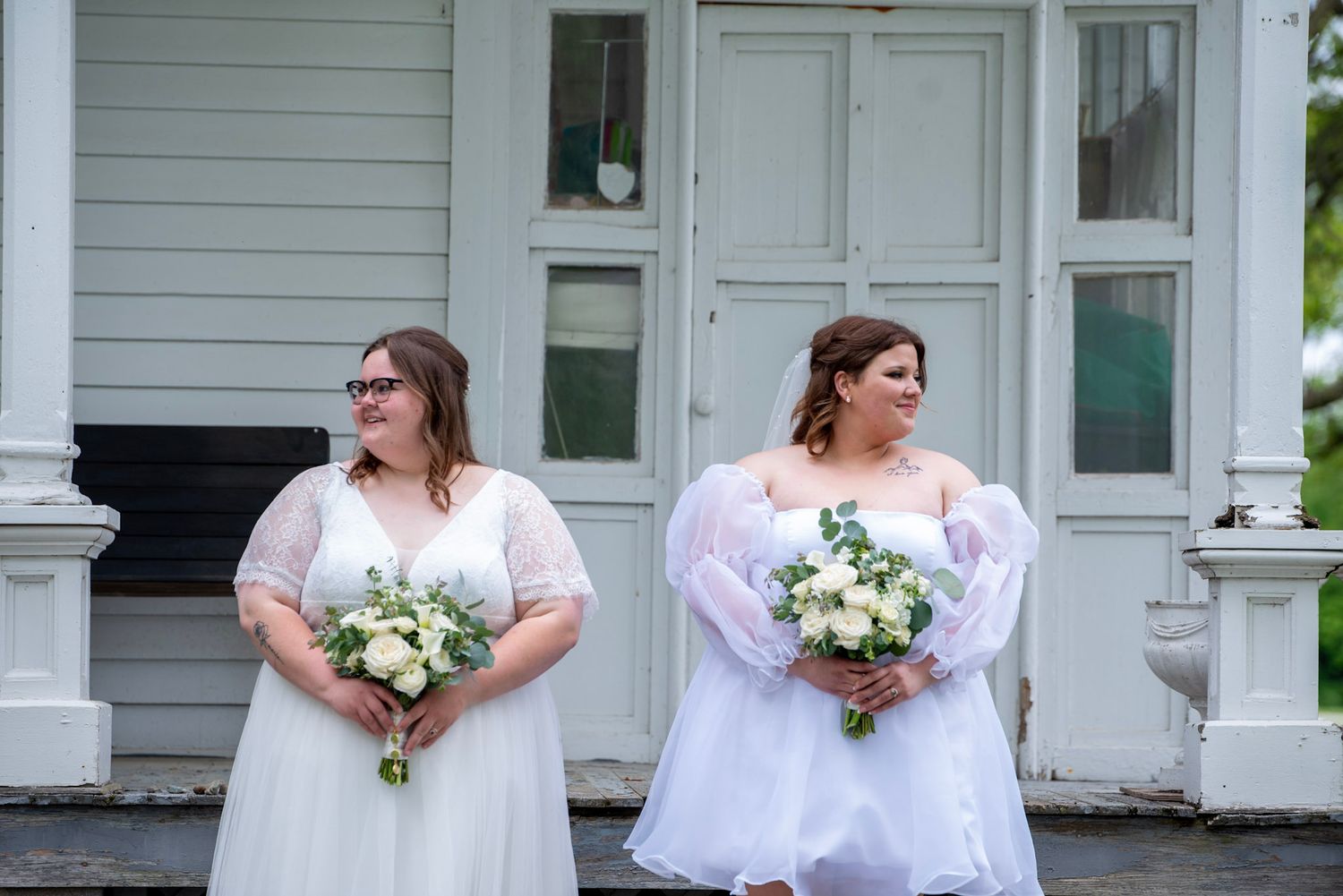 Wedding couple standing on stone steps of vintage building.
