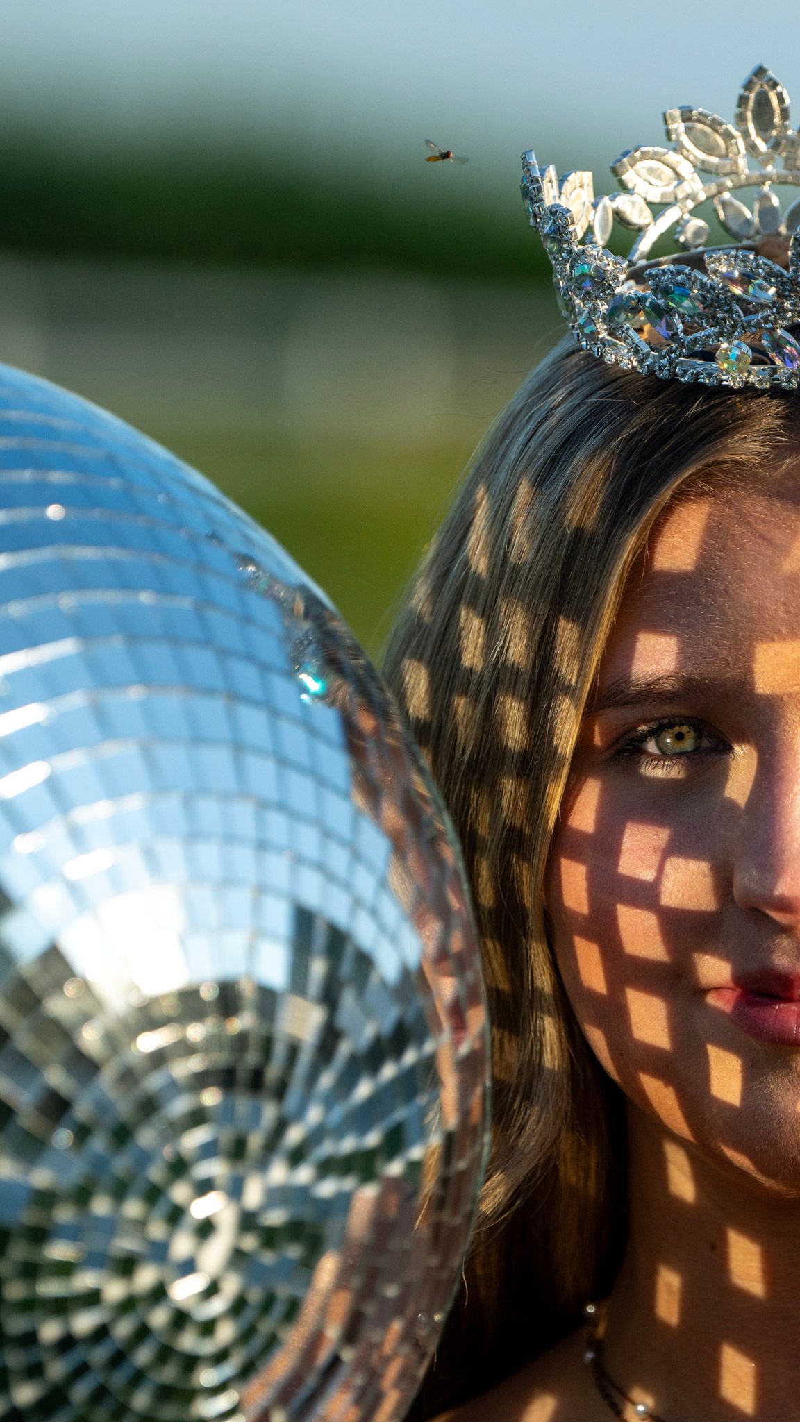 Creative portrait with disco ball reflections creating geometric light patterns.