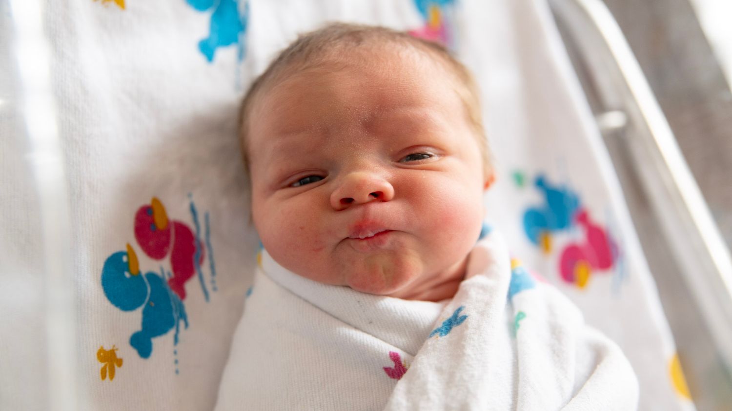Close-up shots of a newborn with colorful decorations in the background.