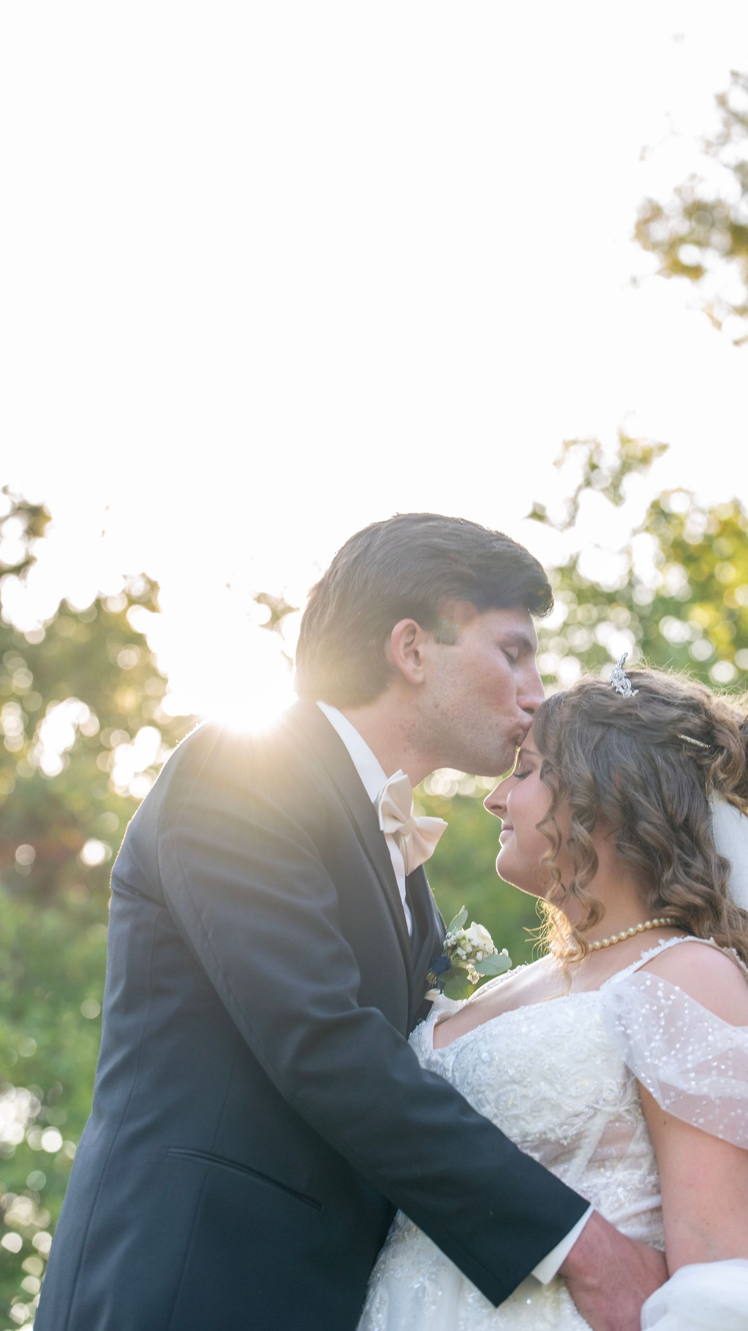 Sunset wedding portraits with golden light filtering through trees.