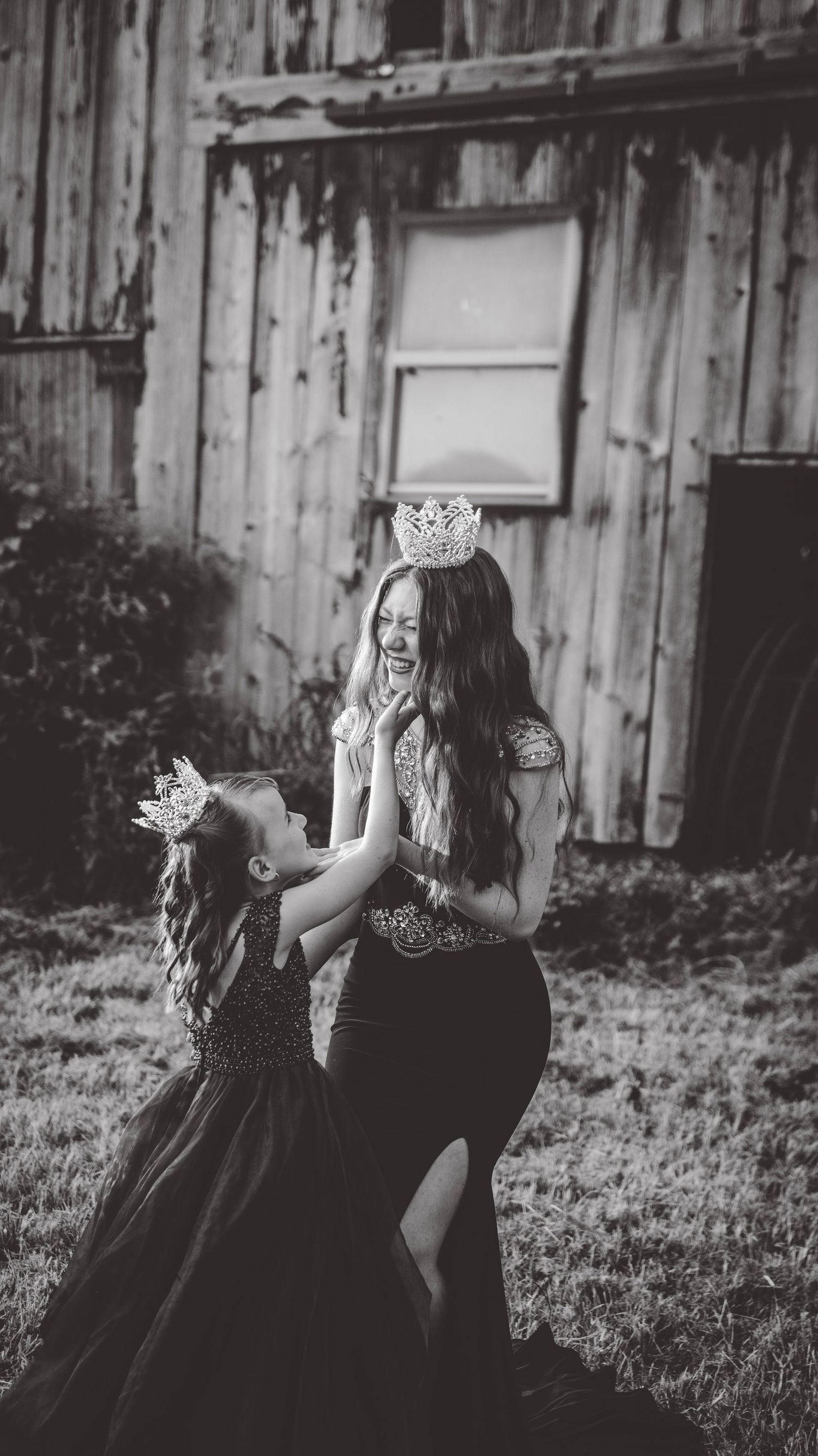 Black and white portraits captured in front of a rustic barn with decorative crowns.