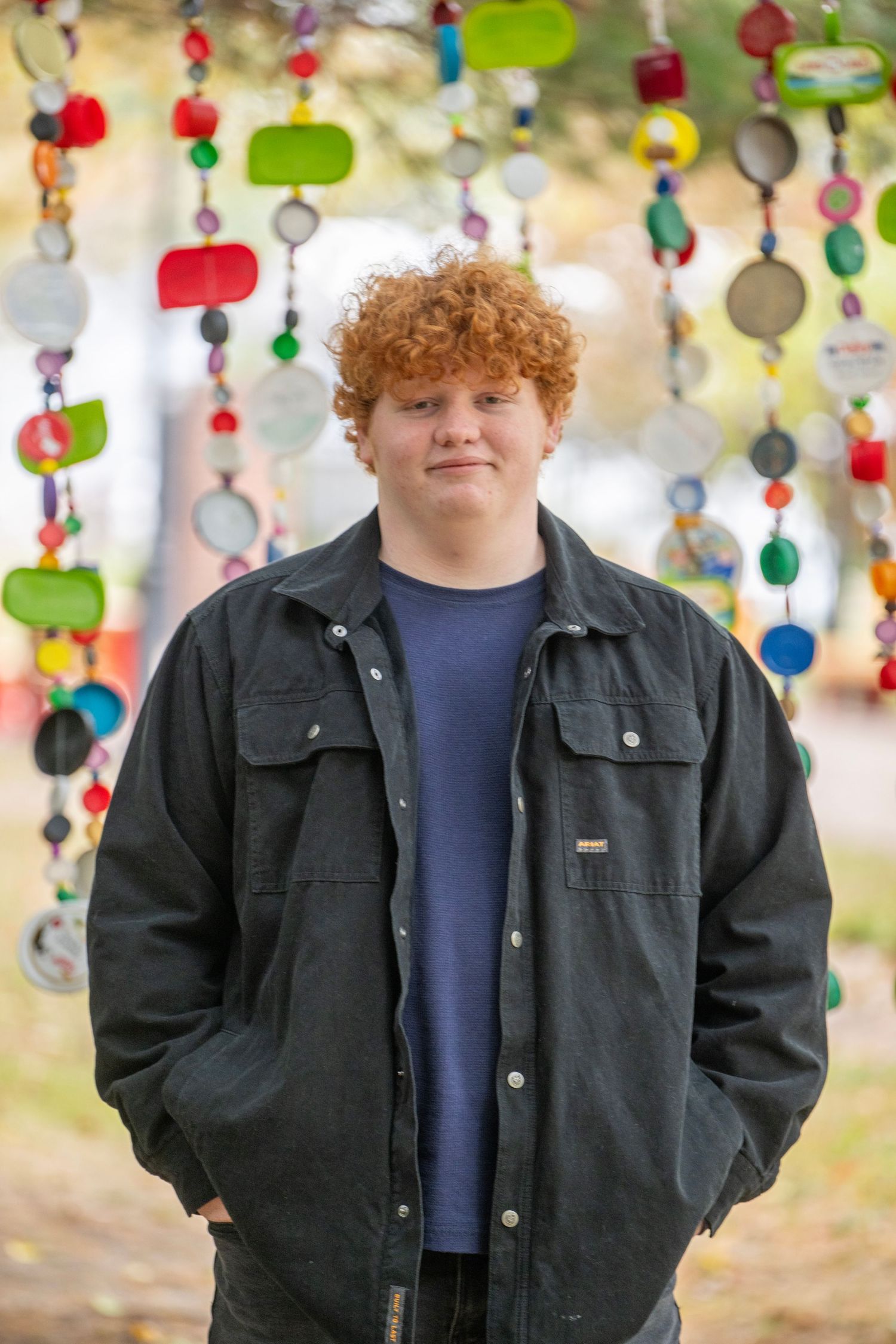 Portrait photos with colorful hanging decorations featuring someone in casual attire.