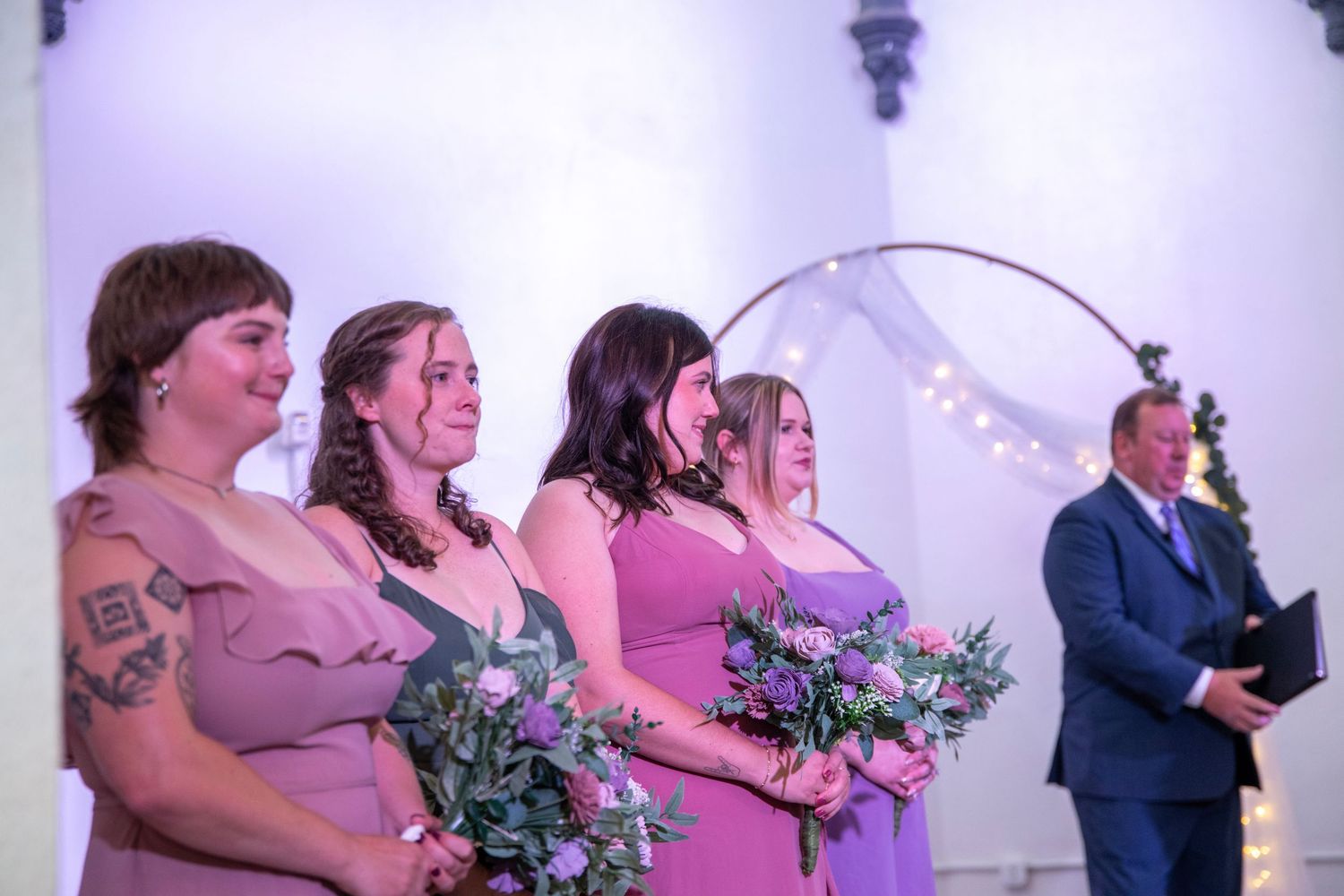 Wedding party members in pink dresses sharing joyful moments.