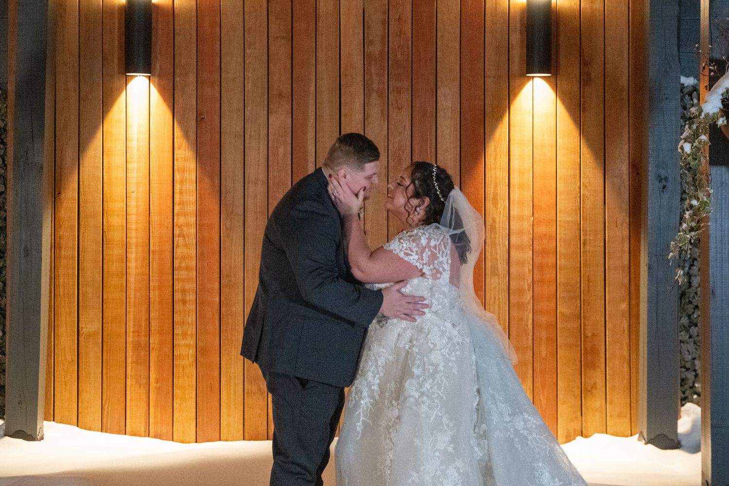 A warmly lit wood-paneled wall creates an intimate backdrop for a special moment.