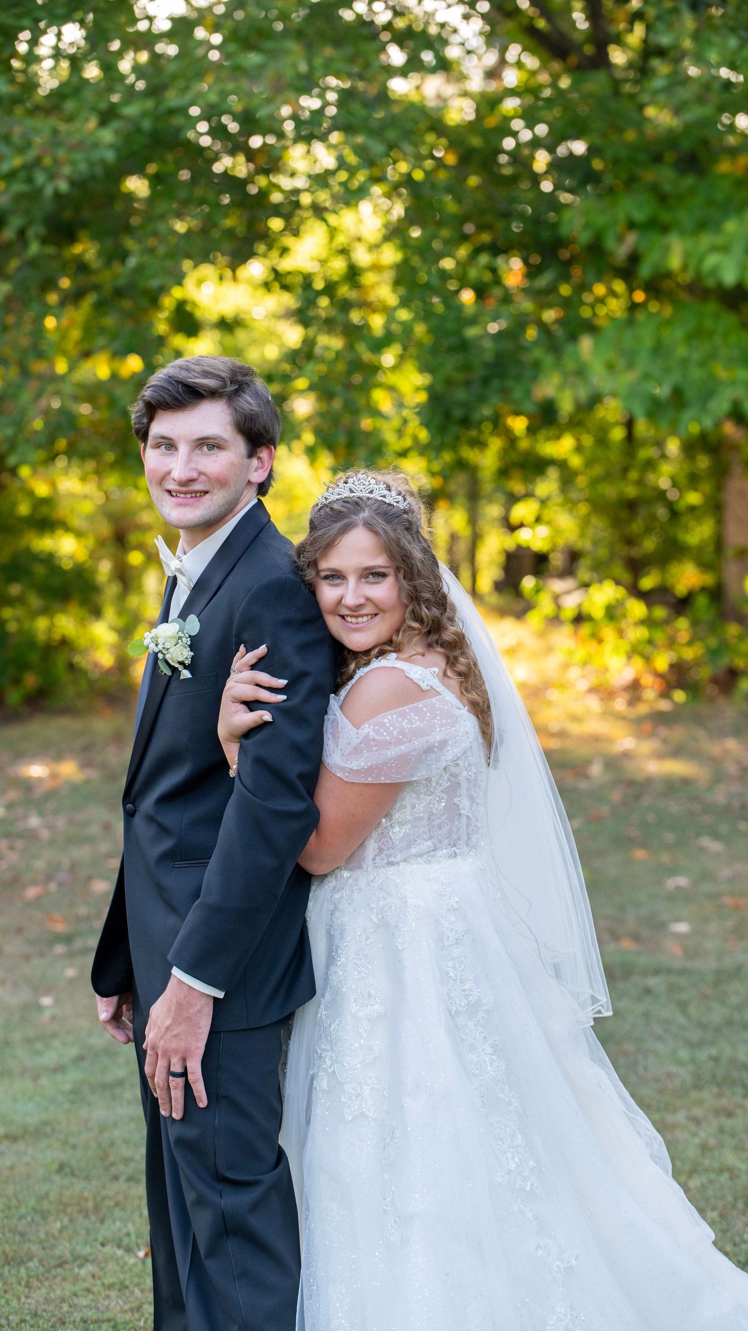 Playful wedding portraits taken outdoors with natural greenery backdrop.