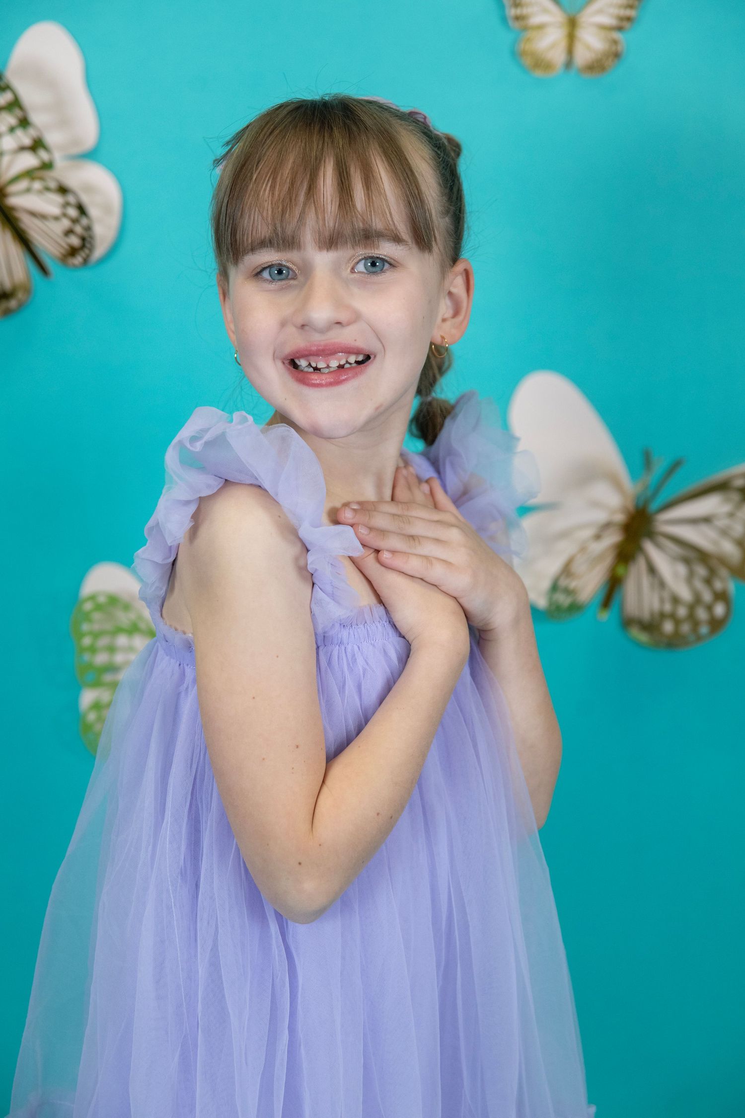 Sweet moment captured in lavender tulle with golden butterflies against turquoise.