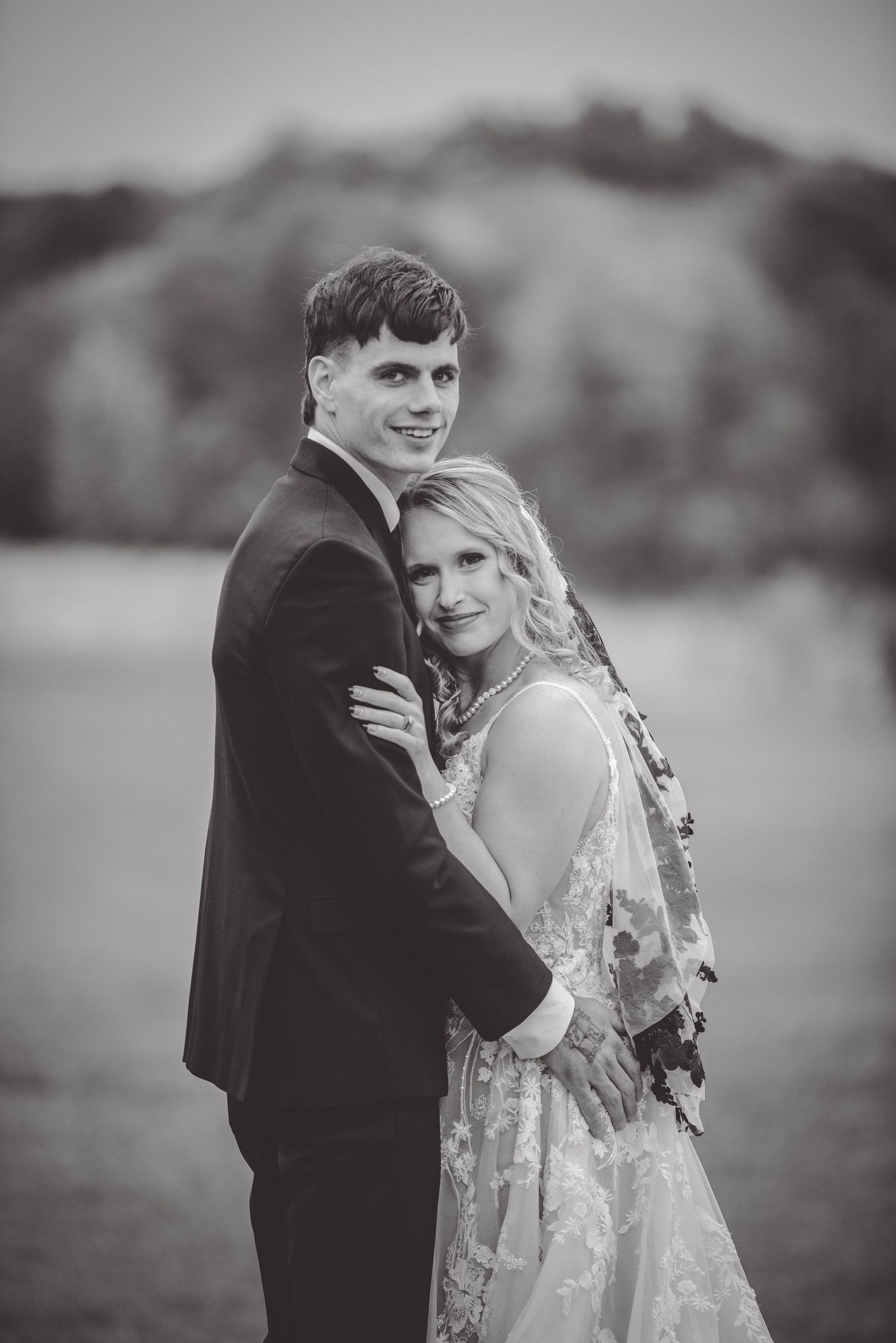 Black and white portrait of a couple sharing an intimate moment in their wedding attire.