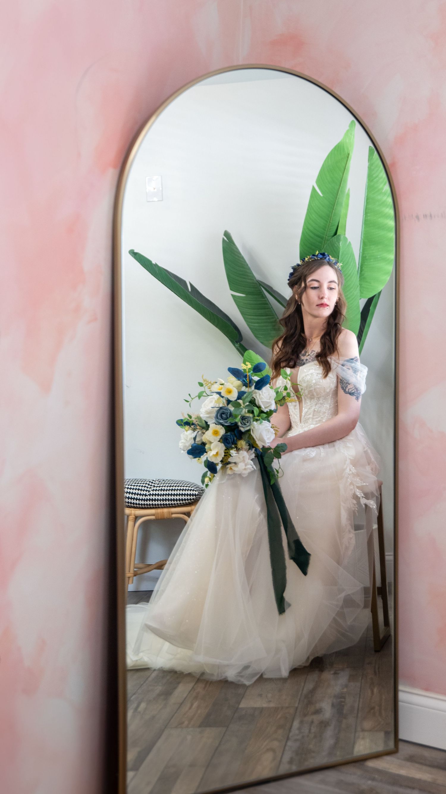 Artistic mirror reflection shot with tropical leaves and yellow floral bouquet accents.