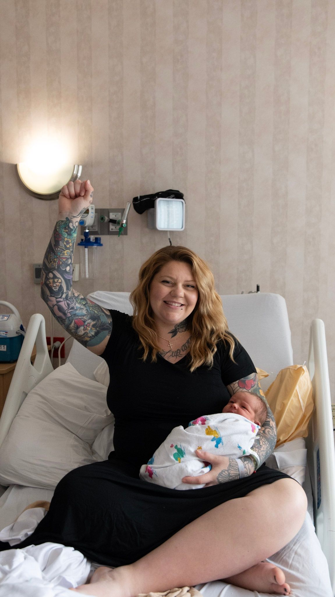 Parents lovingly holding their newborn baby in a bright hospital room.