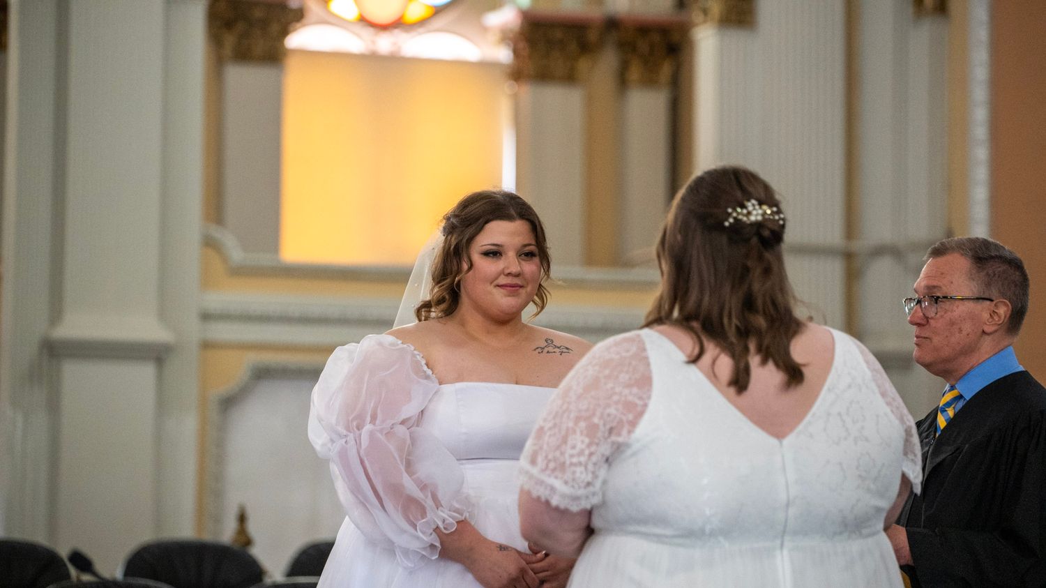 A panoramic view of a wedding ceremony in a grand church with ornate architectural details.