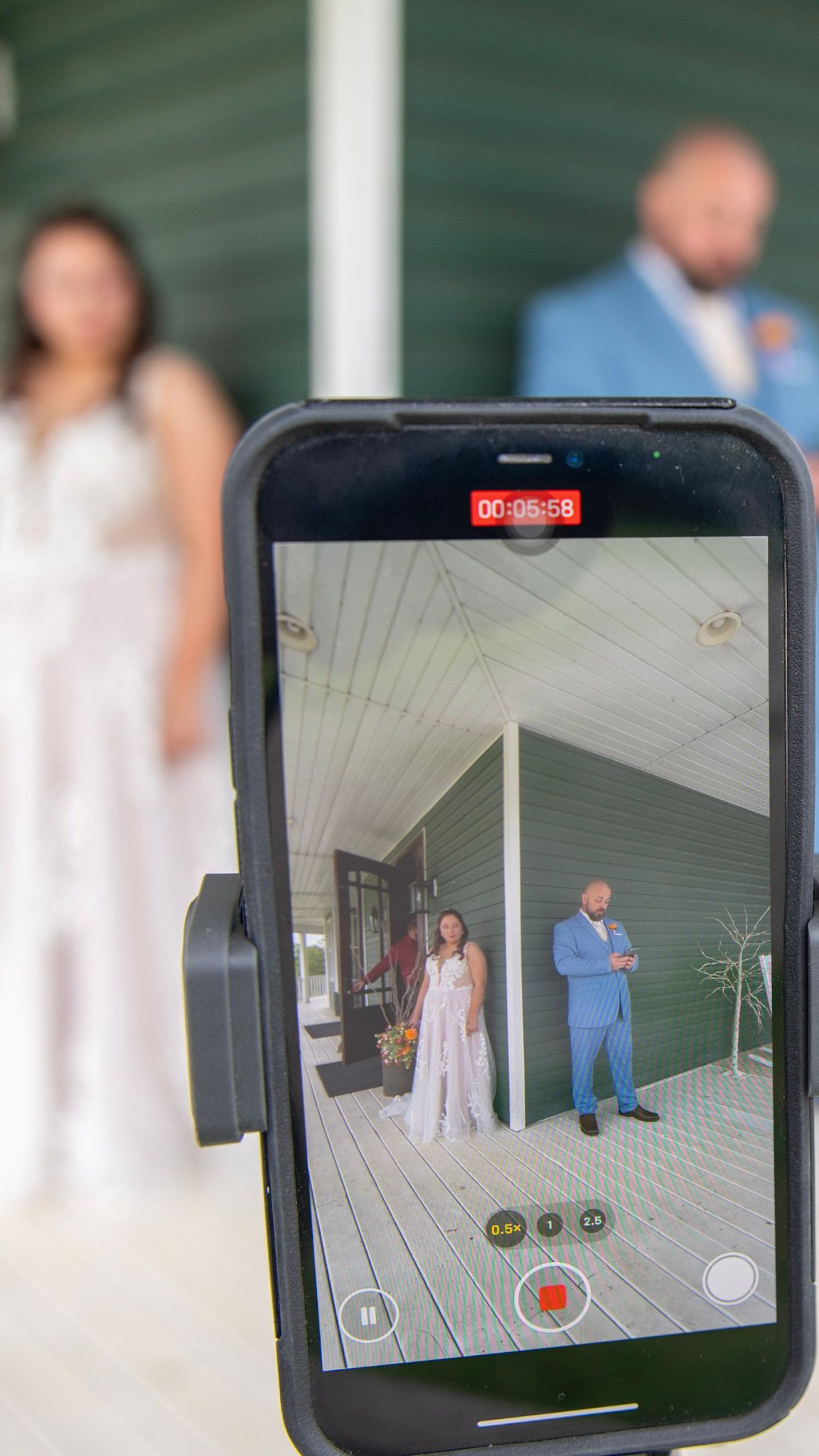 Phone screen showing wedding photography setup on a porch.