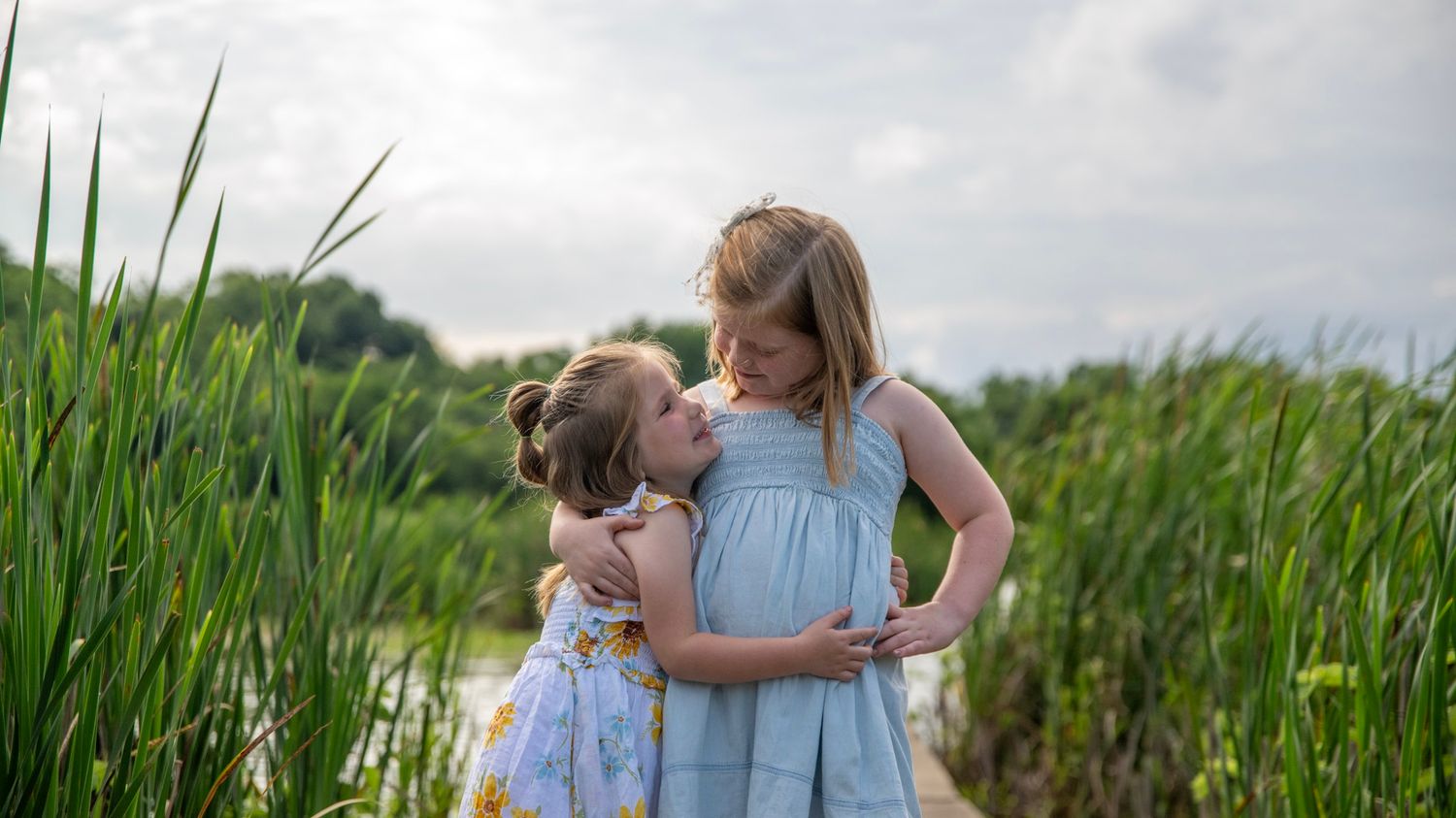 Sweet embrace between parent and child in a field of tall grass.