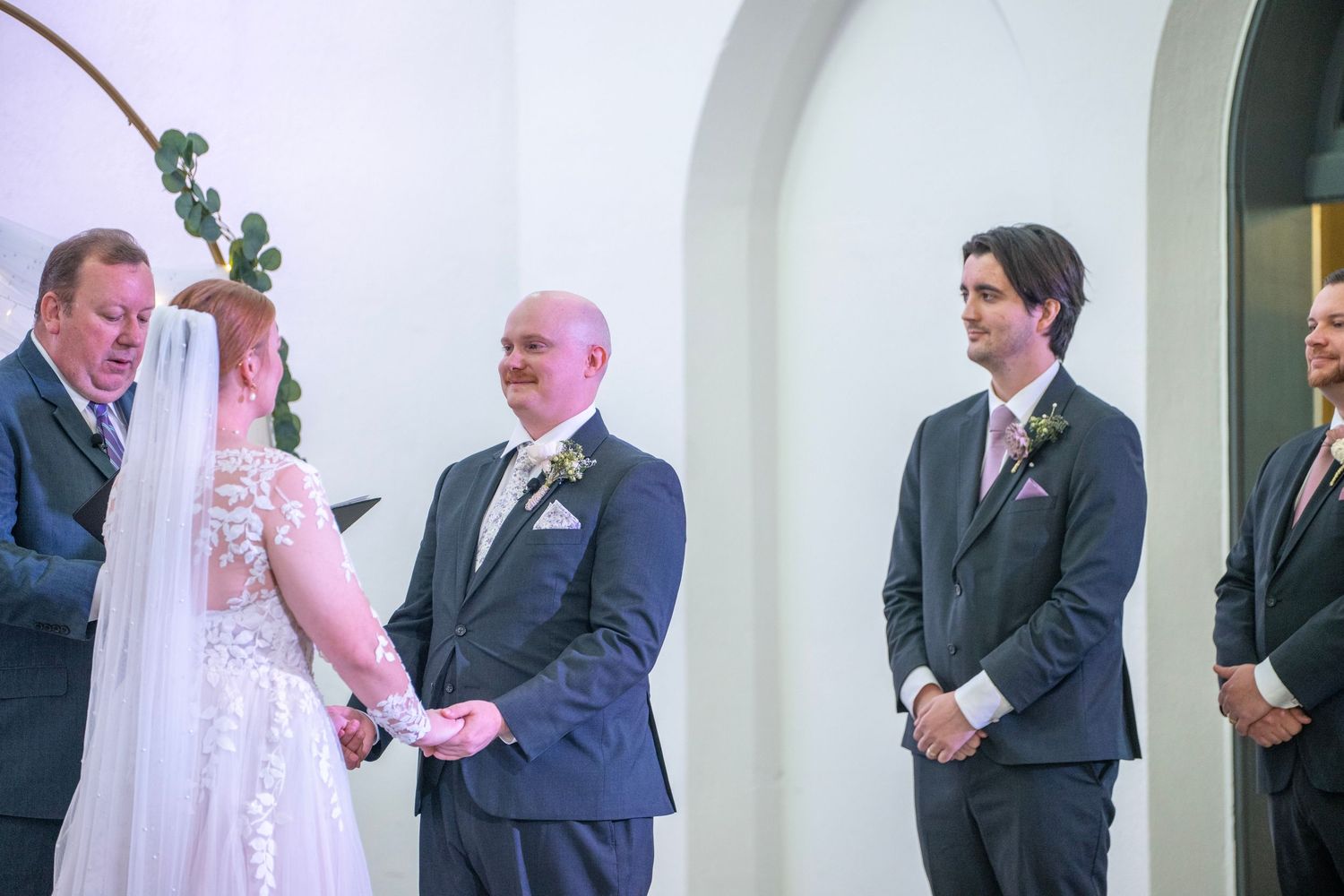 Wedding party members in formal attire during church ceremony.