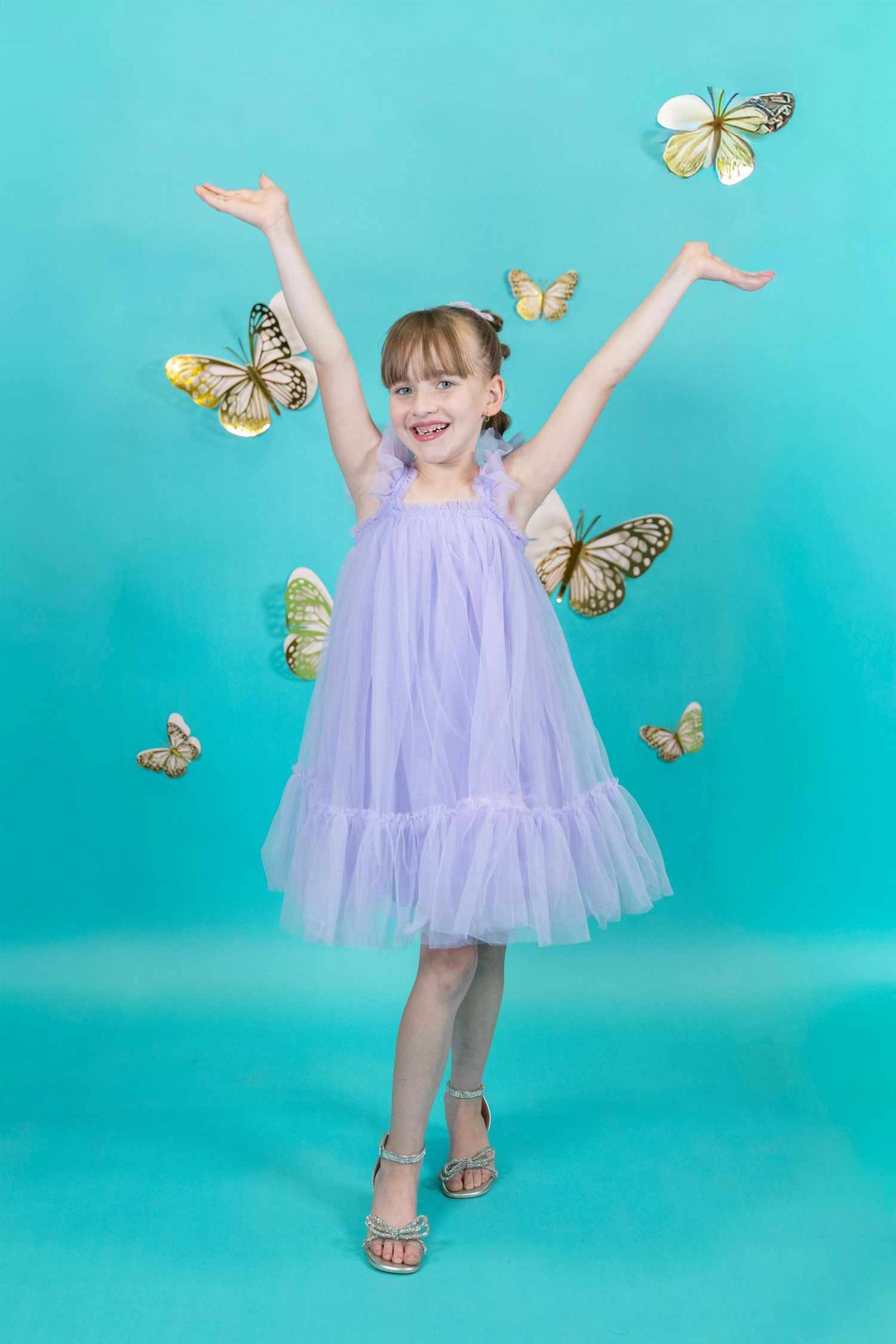 Expressive dance moves in a flowing lavender dress with butterfly decorations.