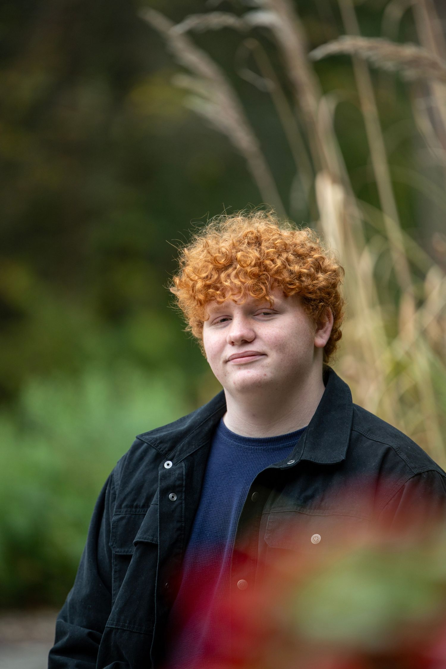 Outdoor portrait series with natural bokeh effect from grass and foliage.