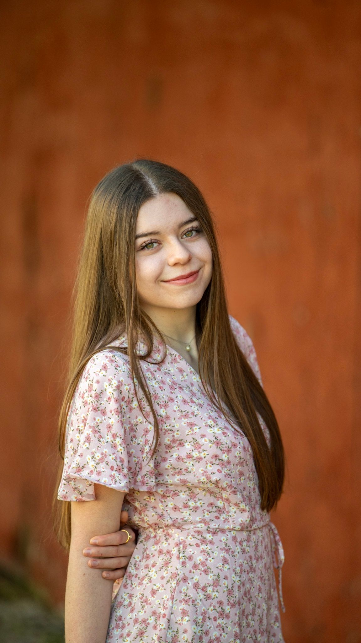 A series of portraits showing someone in a floral print top against a rustic brown background.
