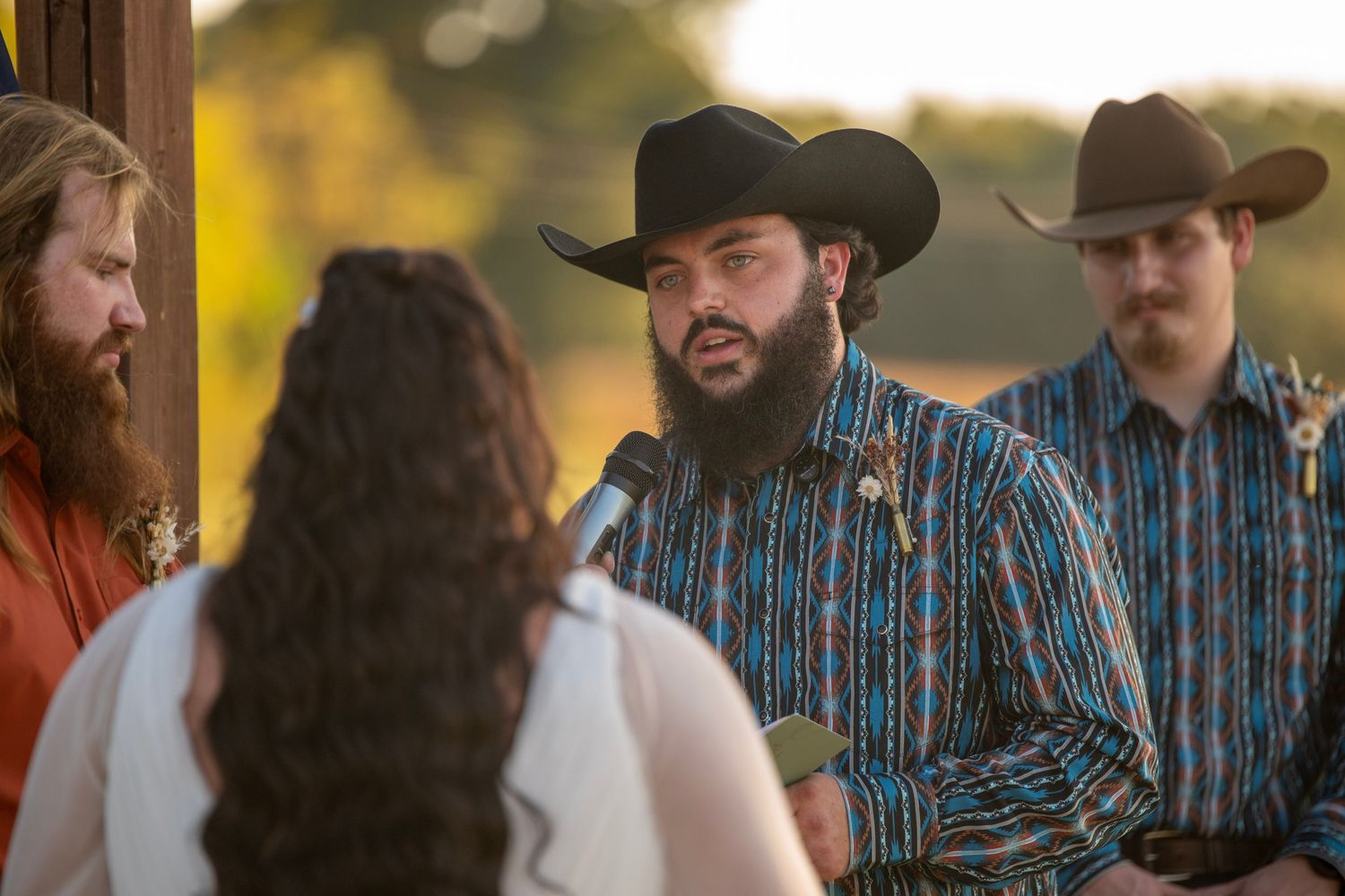 Western-themed wedding ceremony with cowboy hats and casual attire.