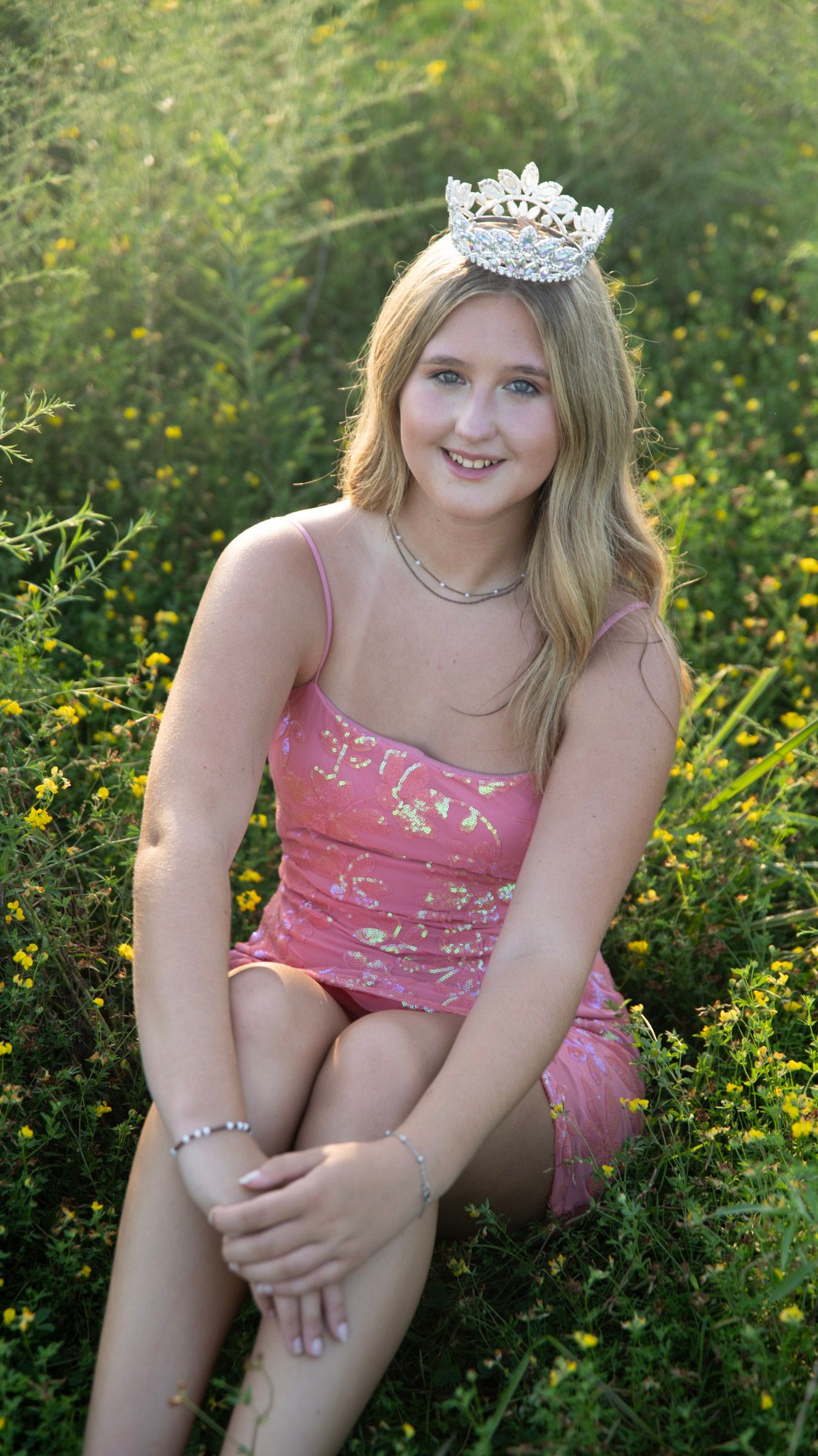 Casual outdoor portrait session among yellow wildflowers in pink summer attire.