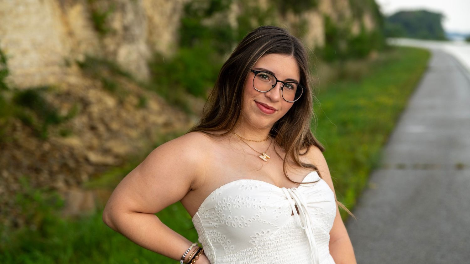 Portrait session along scenic pathway with stone wall backdrop.
