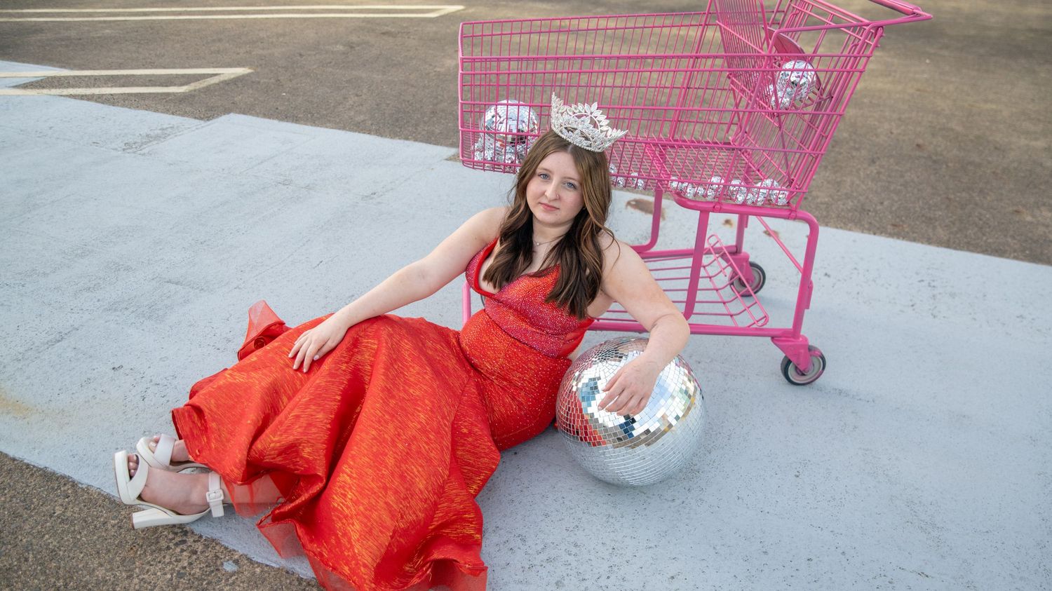 A fashion photography series featuring a red dress and pink shopping carts in an outdoor setting.